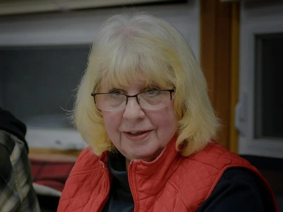 Emblem of Sanders County Montana Chamber of Commerce featuring a deer with large antlers against a mountain landscape background.