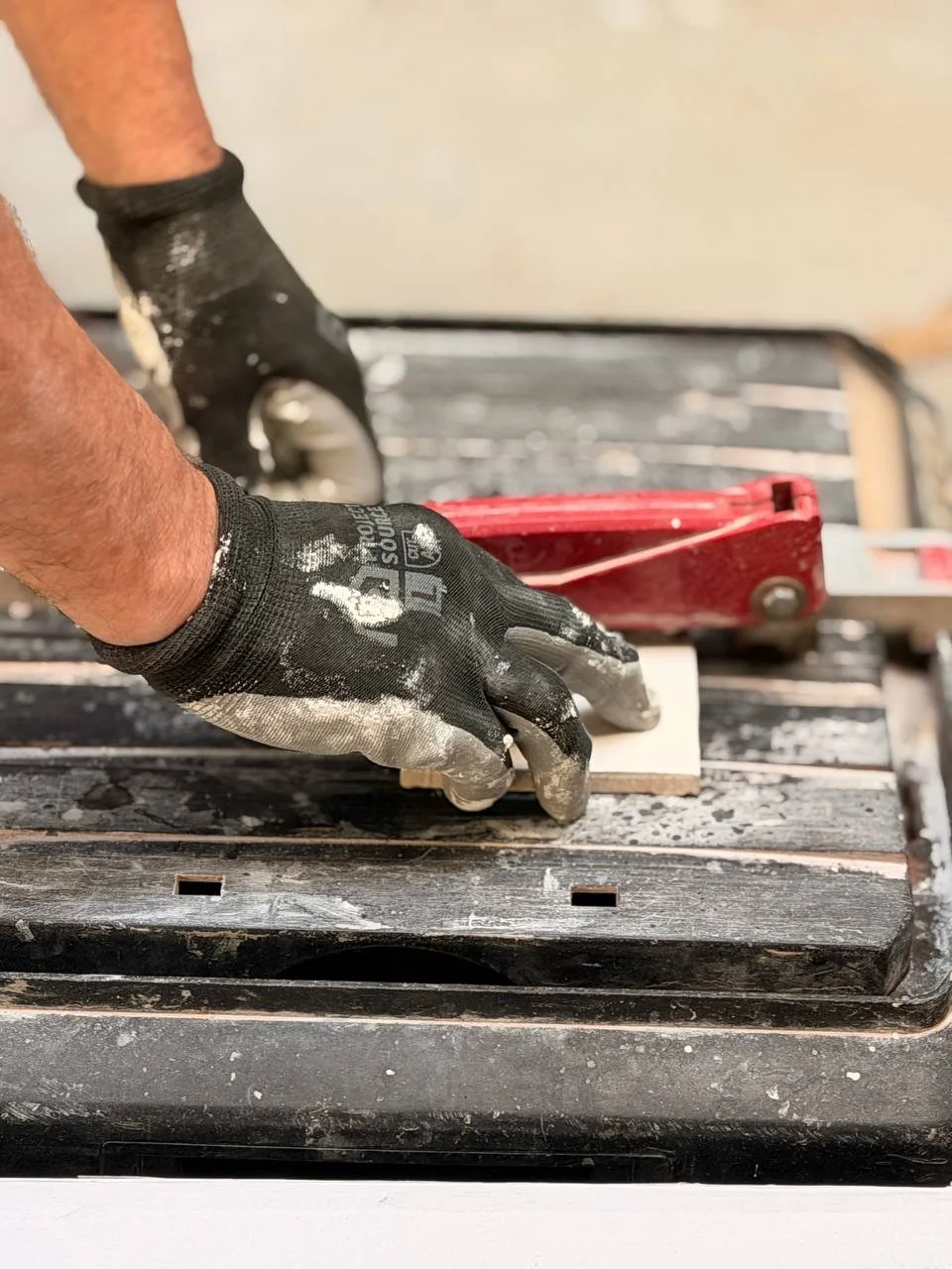 A person using a hand planer on a piece of wood in a workshop.