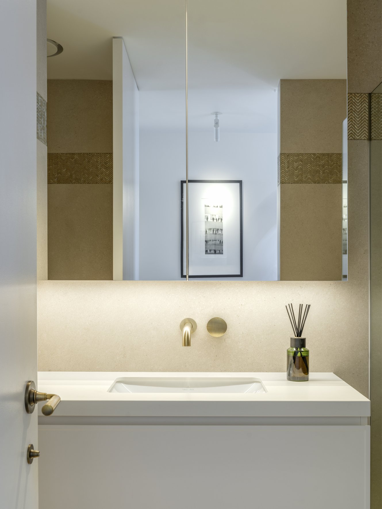 Potts Point Unit 2024 — high-end apartment renovation in Sydney featuring bespoke joinery, herringbone timber flooring with brass inlay, integrated lighting and a cohesive open-plan kitchen, living and dining space.