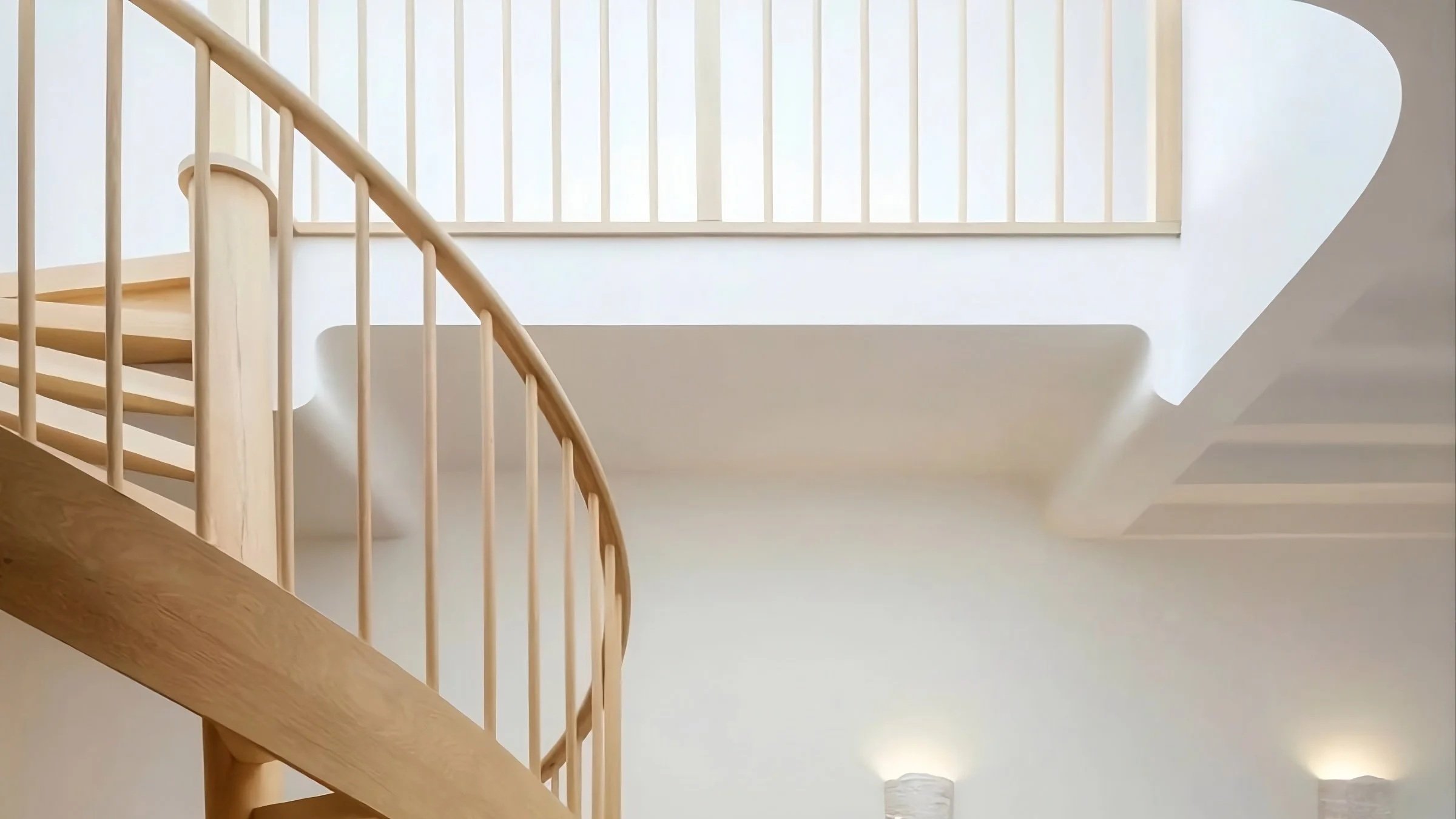 A contemporary kitchen within the Bronte House project by To The Mil, defined by natural timber cabinetry, a large marble island and an elegant arched opening connecting the interior to the outdoor terrace.