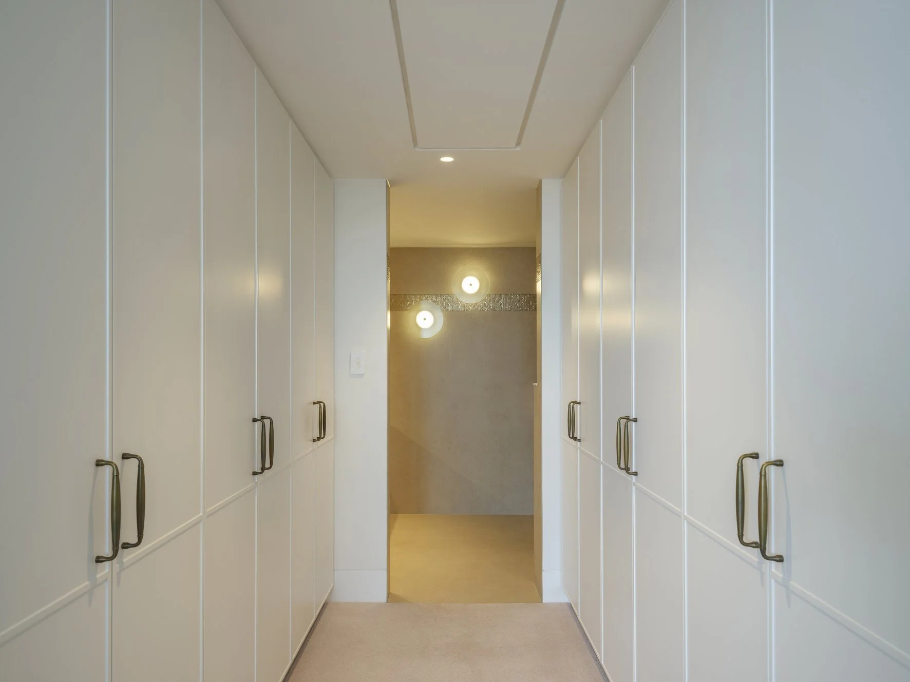 Potts Point Unit 2024 — high-end apartment renovation in Sydney featuring bespoke joinery, herringbone timber flooring with brass inlay, integrated lighting and a cohesive open-plan kitchen, living and dining space.