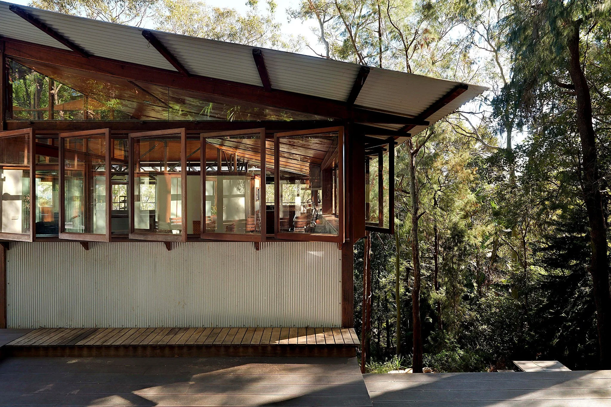 Timber-framed windows opening from the Tree Top House verandah toward the surrounding Avalon bushland.