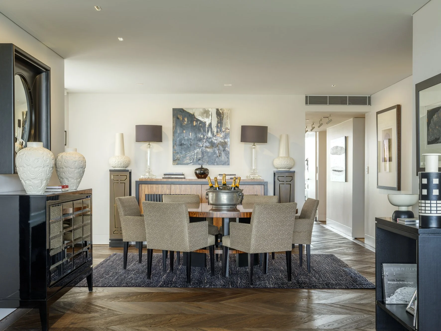 Potts Point Unit 2024 — high-end apartment renovation in Sydney featuring bespoke joinery, herringbone timber flooring with brass inlay, integrated lighting and a cohesive open-plan kitchen, living and dining space.