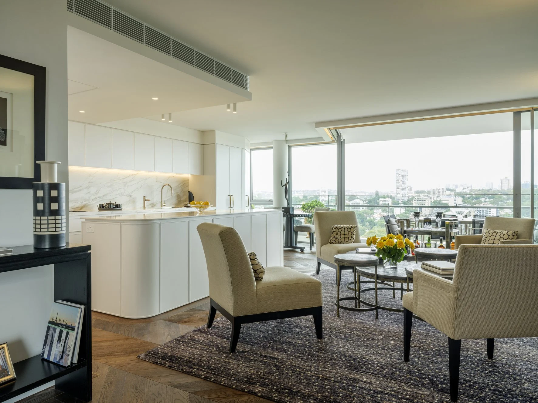 Potts Point Unit 2024 — high-end apartment renovation in Sydney featuring bespoke joinery, herringbone timber flooring with brass inlay, integrated lighting and a cohesive open-plan kitchen, living and dining space.
