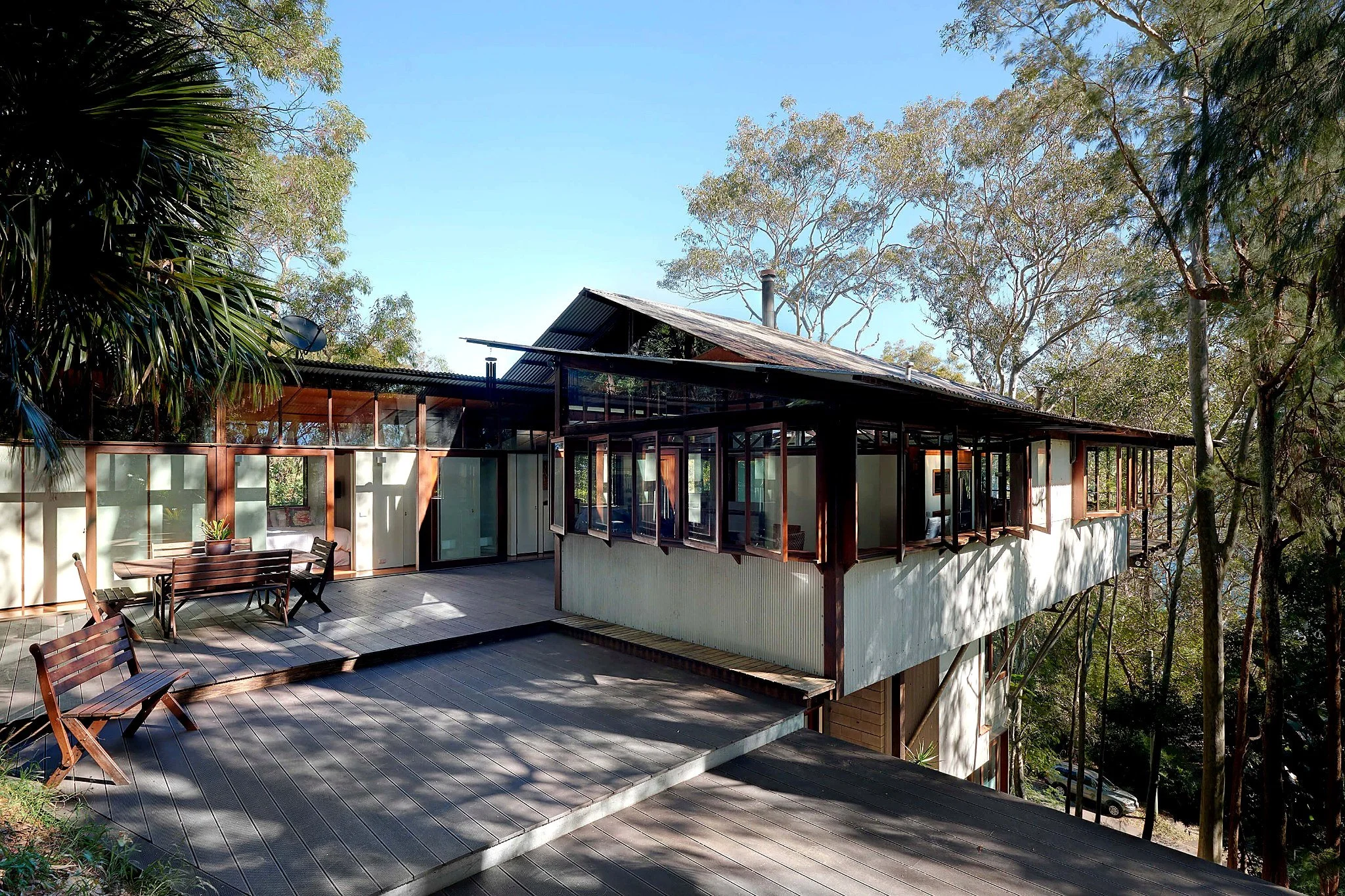 Outdoor dining terrace at Tree Top House, surrounded by mature trees on its elevated Avalon site.