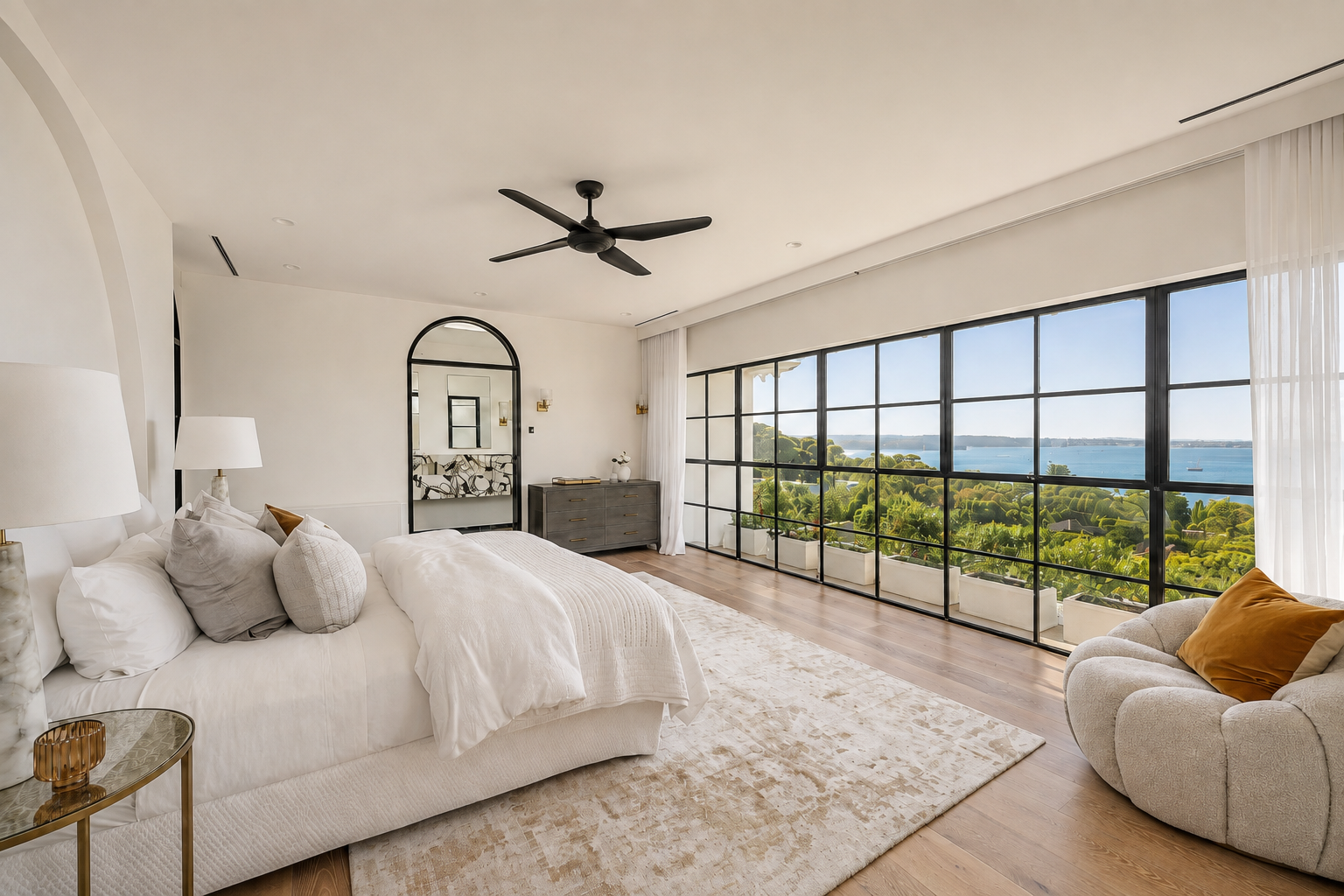Vaucluse House bedroom with expansive black-framed windows, timber flooring and panoramic Sydney Harbour views.