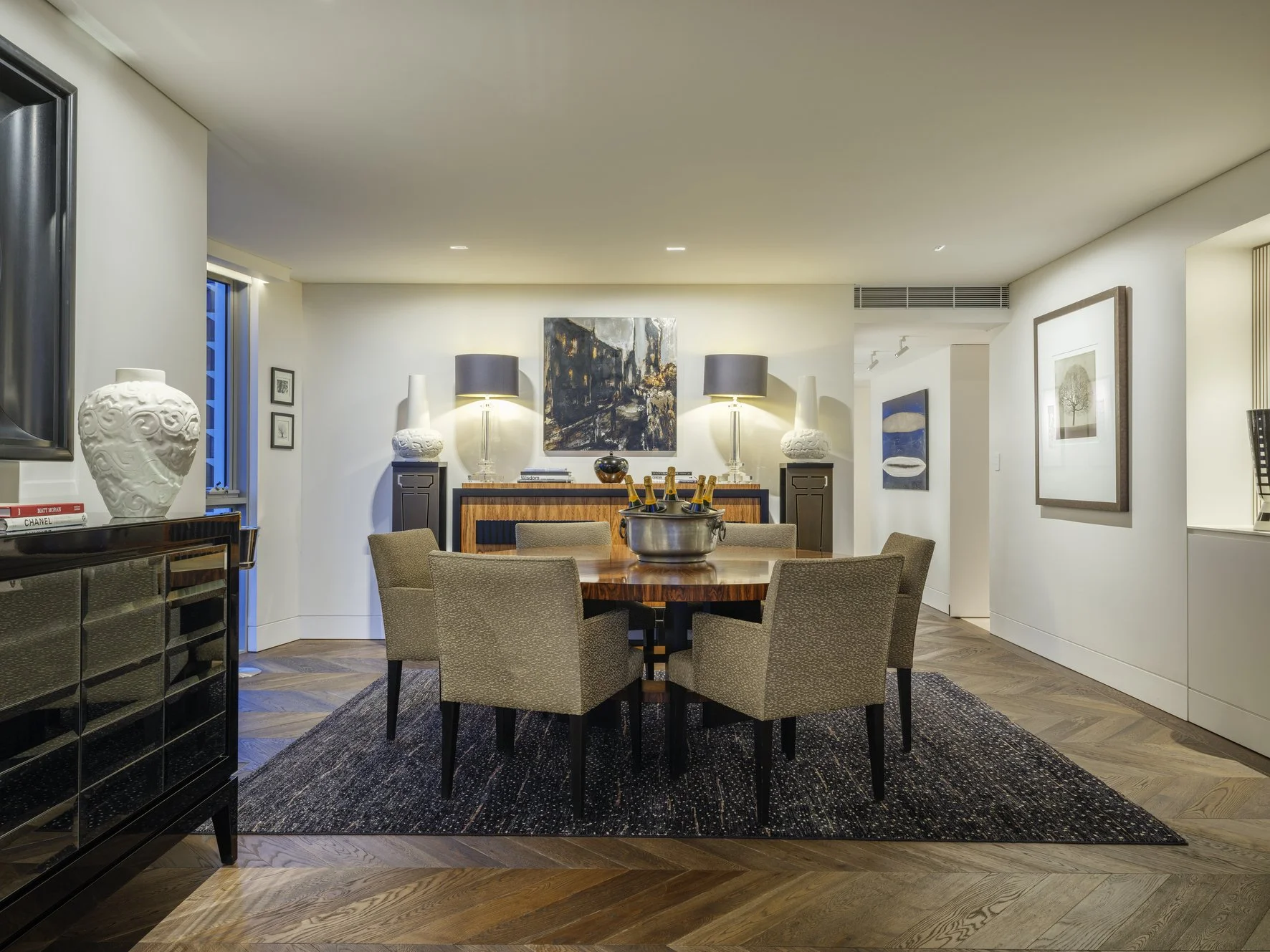Potts Point Unit 2024 — high-end apartment renovation in Sydney featuring bespoke joinery, herringbone timber flooring with brass inlay, integrated lighting and a cohesive open-plan kitchen, living and dining space.