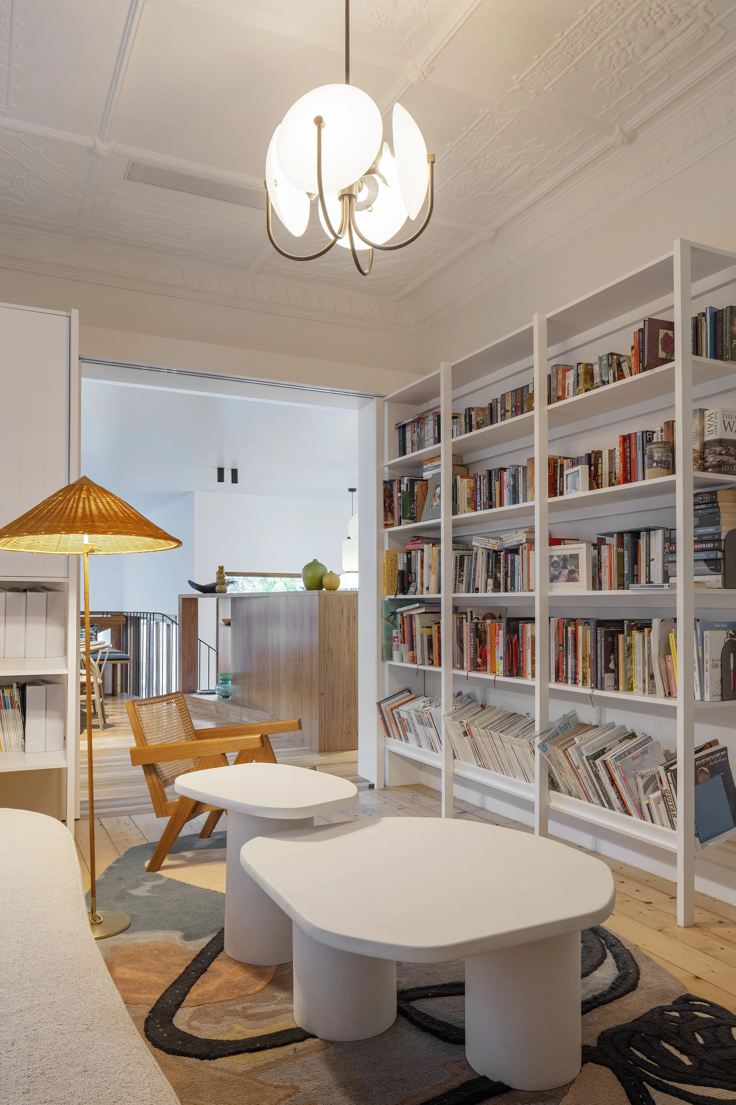 Coogee home interior with a built-in bookcase, sculptural coffee table and timber furniture.