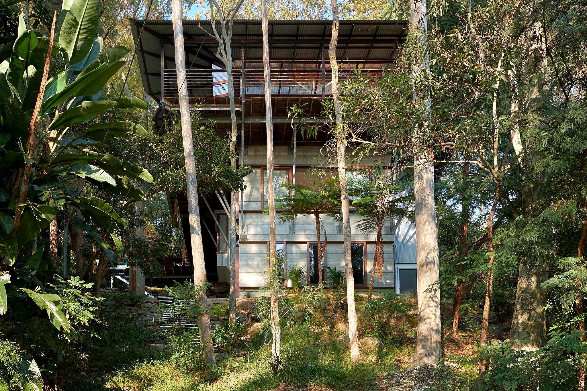Exterior of Tree Top House by Peter Stutchbury, showing its blockwork tower and elevated living platform.