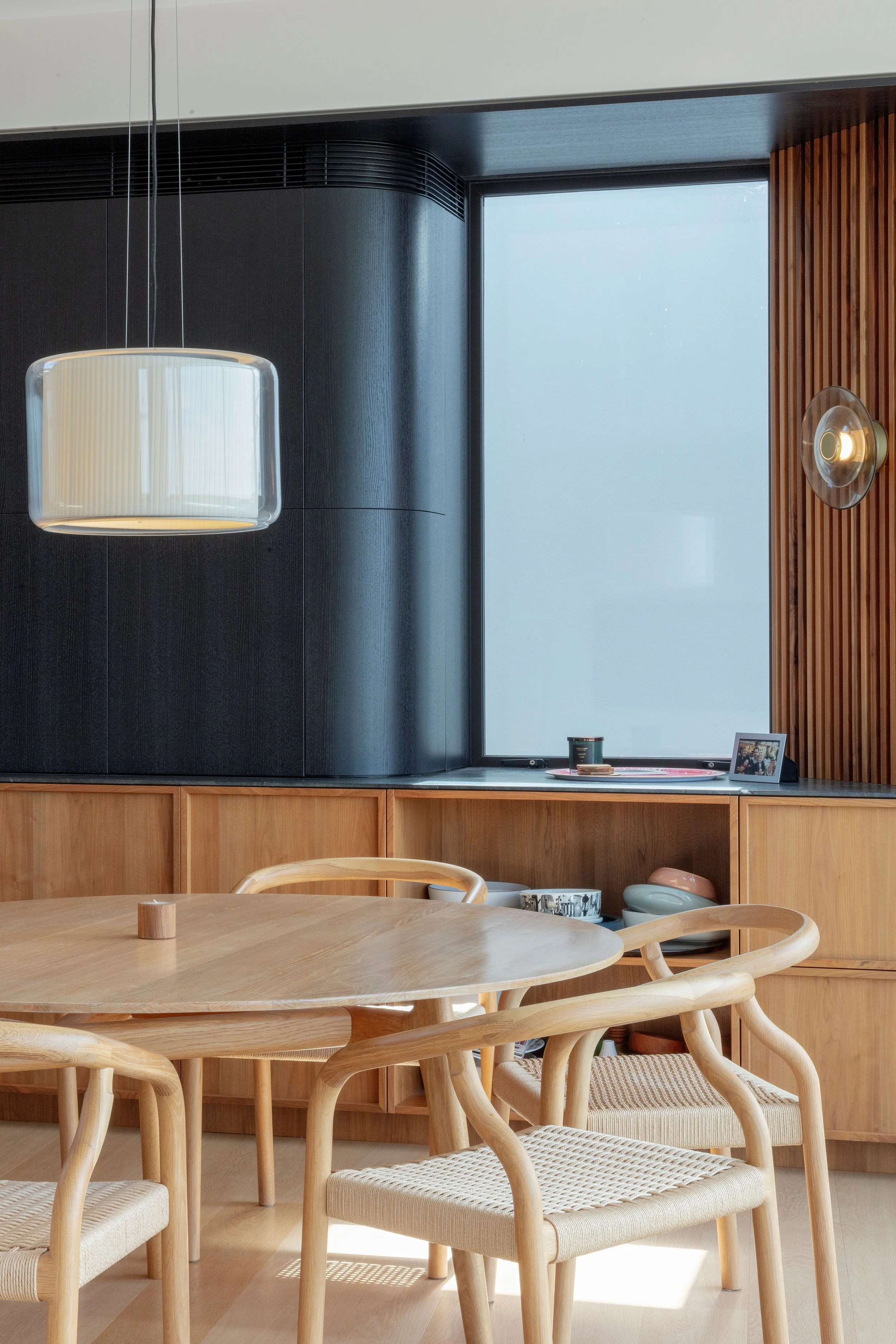 Dining area at the Blandford Street, Bronte home, with a timber table, curved chairs and garden views.