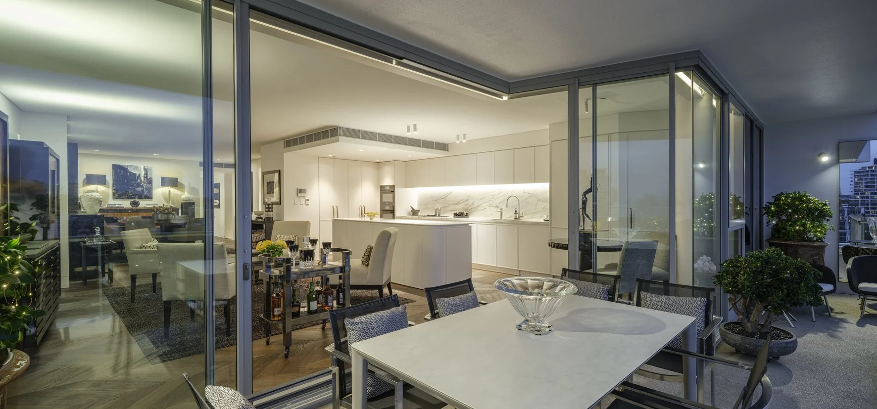 Potts Point Unit 2024 — high-end apartment renovation in Sydney featuring bespoke joinery, herringbone timber flooring with brass inlay, integrated lighting and a cohesive open-plan kitchen, living and dining space.