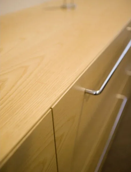 Close-up of a wooden cabinet or dresser with a metal handle.