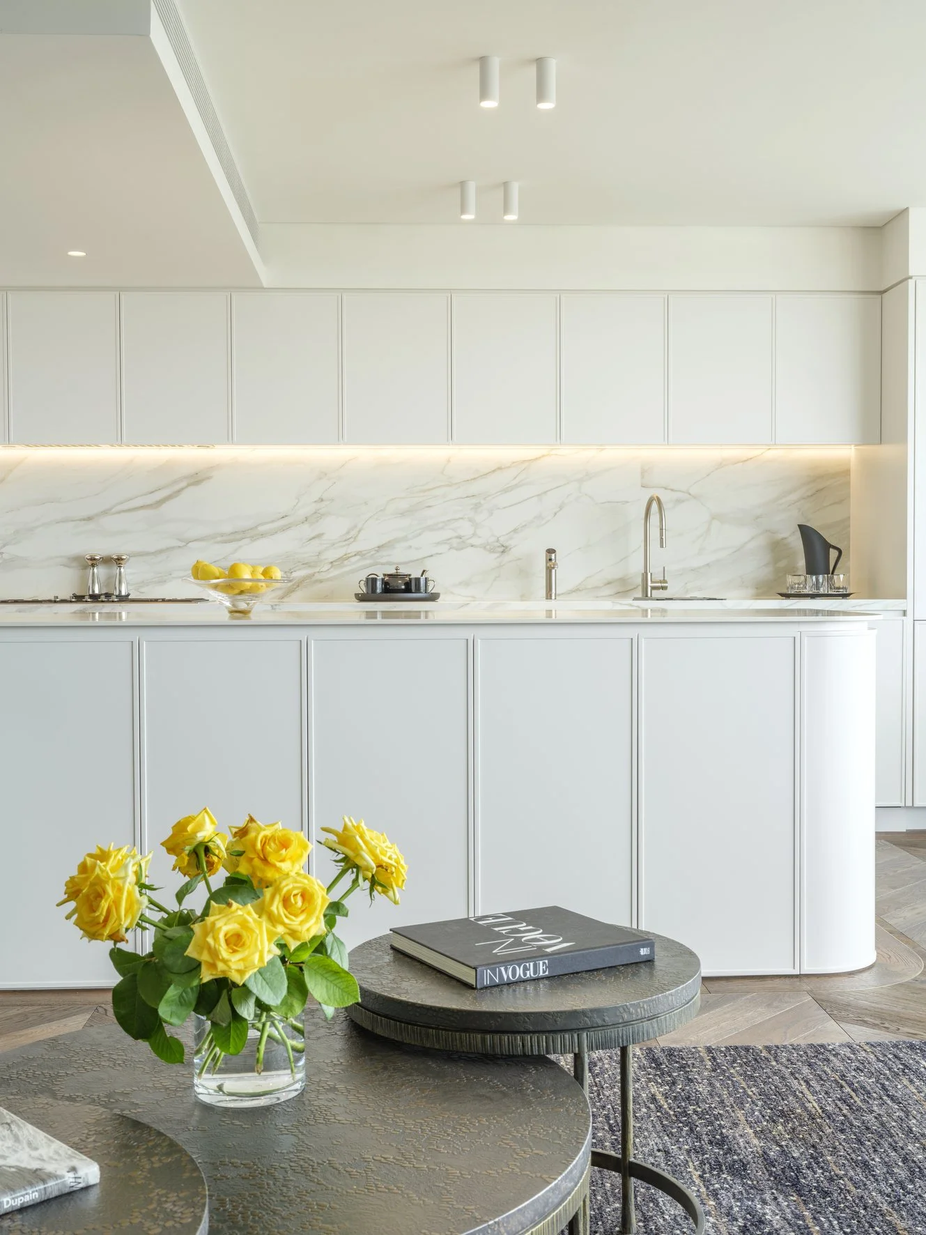 Potts Point Unit 2024 — high-end apartment renovation in Sydney featuring bespoke joinery, herringbone timber flooring with brass inlay, integrated lighting and a cohesive open-plan kitchen, living and dining space.