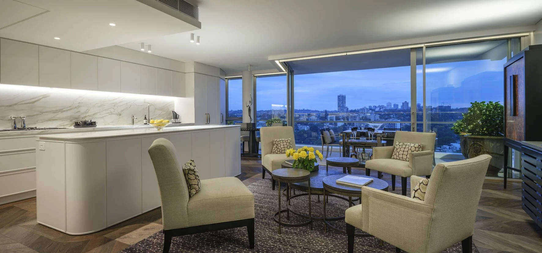 Potts Point Unit 2024 — high-end apartment renovation in Sydney featuring bespoke joinery, herringbone timber flooring with brass inlay, integrated lighting and a cohesive open-plan kitchen, living and dining space.