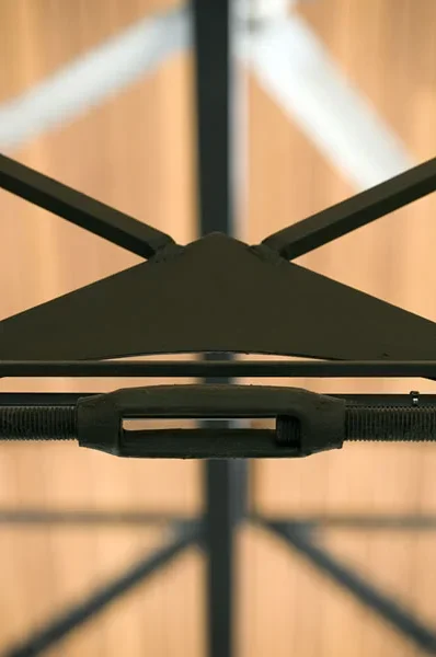 Close-up of a black drying rack with a wooden floor in the background.