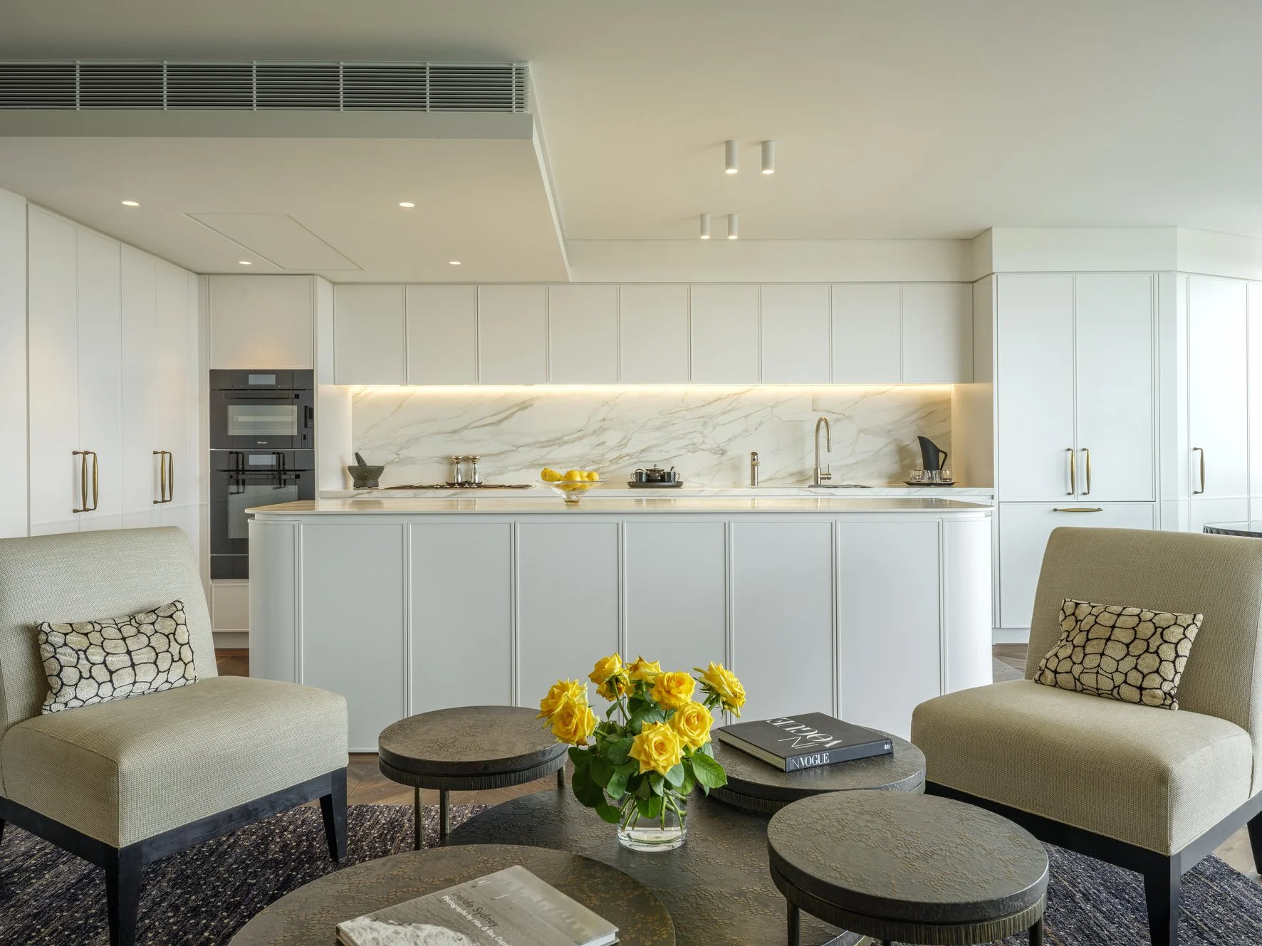 Potts Point Unit 2024 — high-end apartment renovation in Sydney featuring bespoke joinery, herringbone timber flooring with brass inlay, integrated lighting and a cohesive open-plan kitchen, living and dining space.
