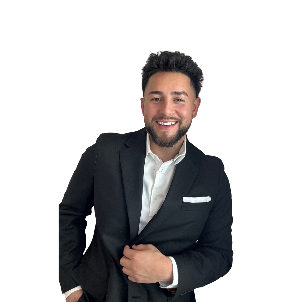 HomeLoanSammy smiling with dark hair and a beard wearing a black suit and white shirt, posing in front of a plain background.