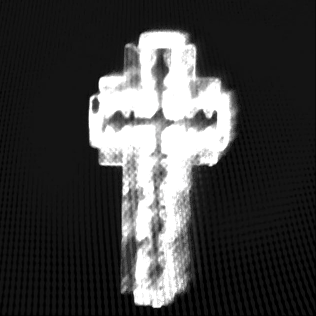 Black and white image of a cross with a human face outline in the center.