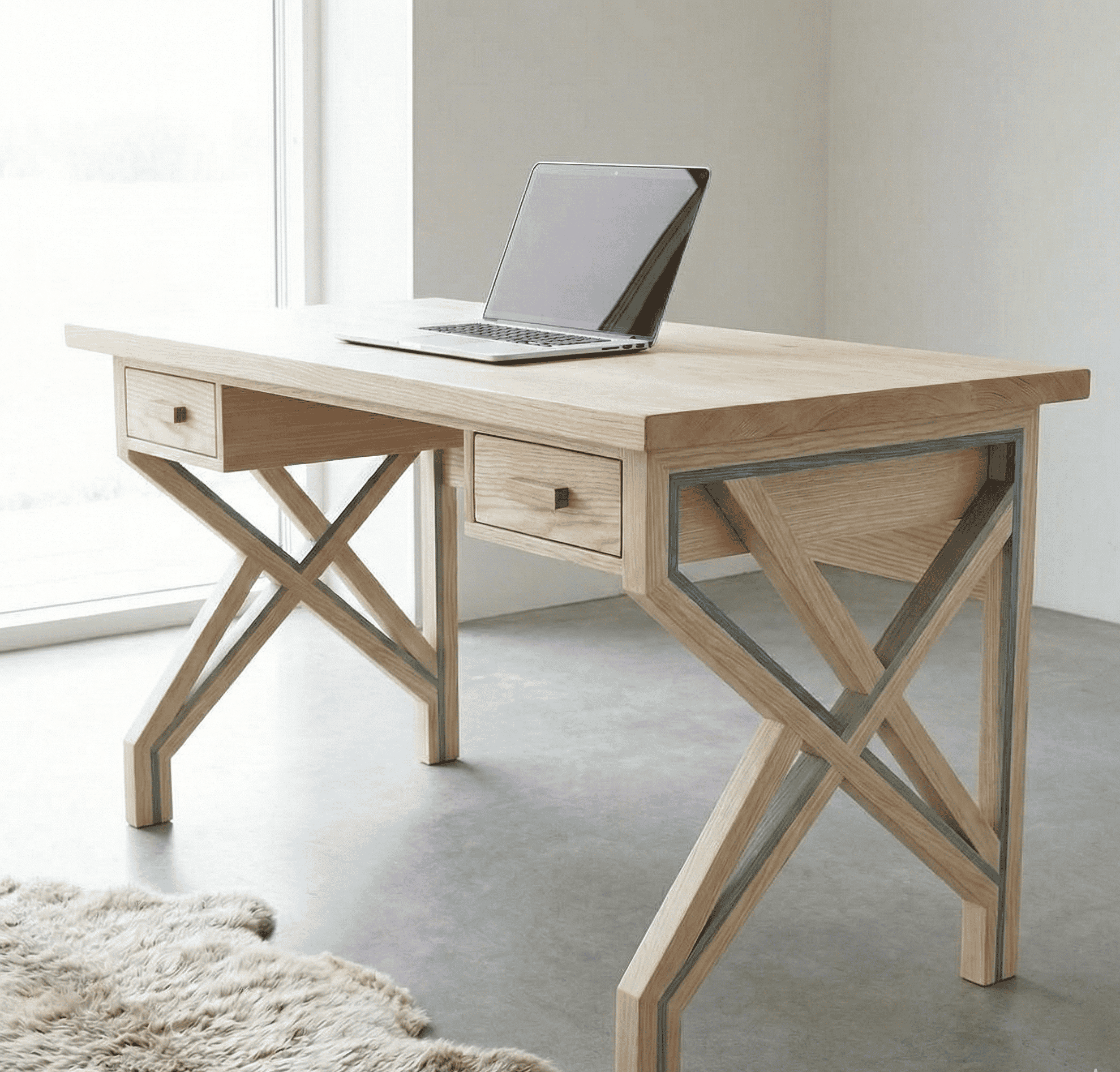 Wooden desk with two drawers and crossed legs, placed near a window with a laptop on top.