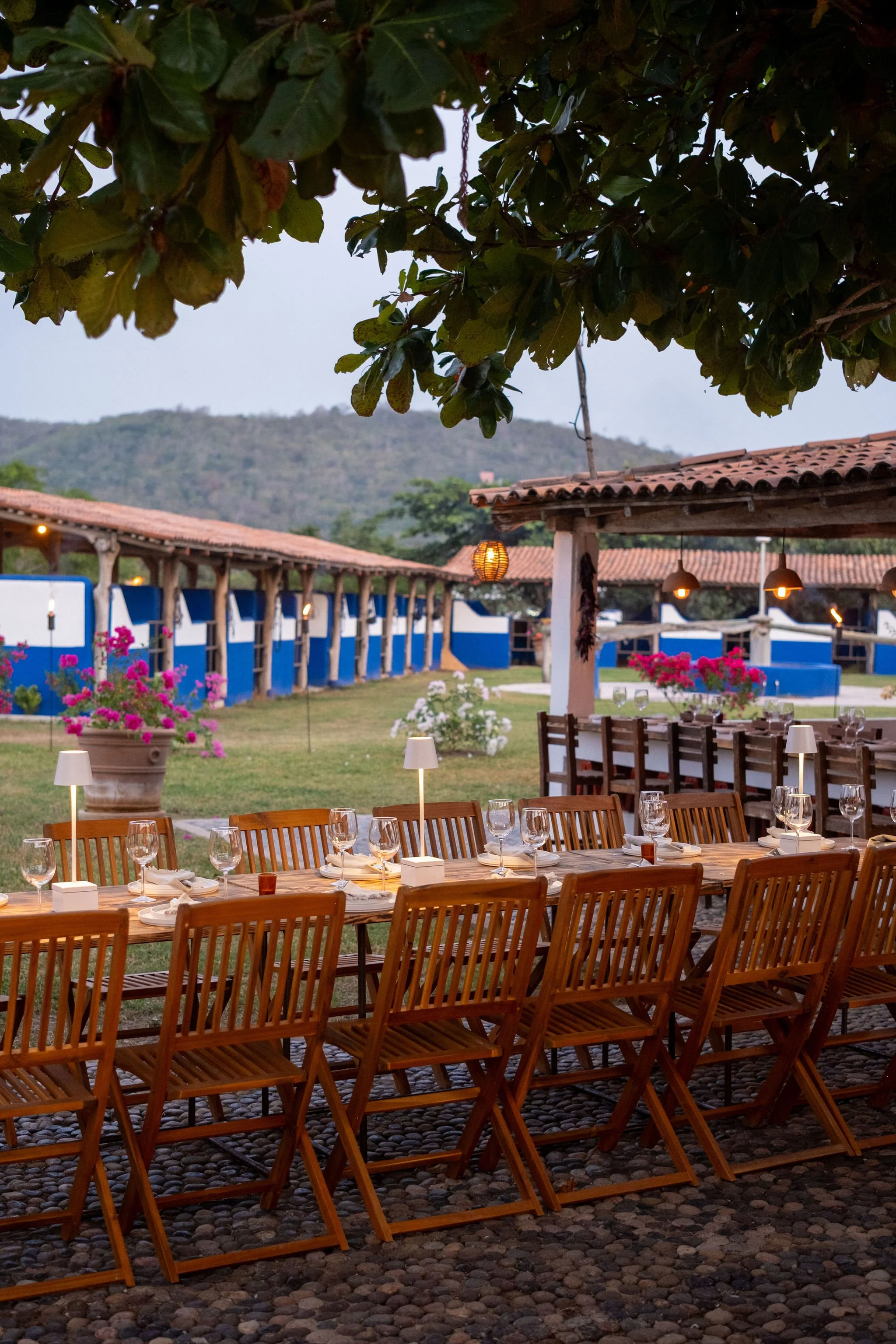 Una mesa de madera preparada frente a las caballerizas de careyes para una cena al aire libre en el restaurante malabar careyes