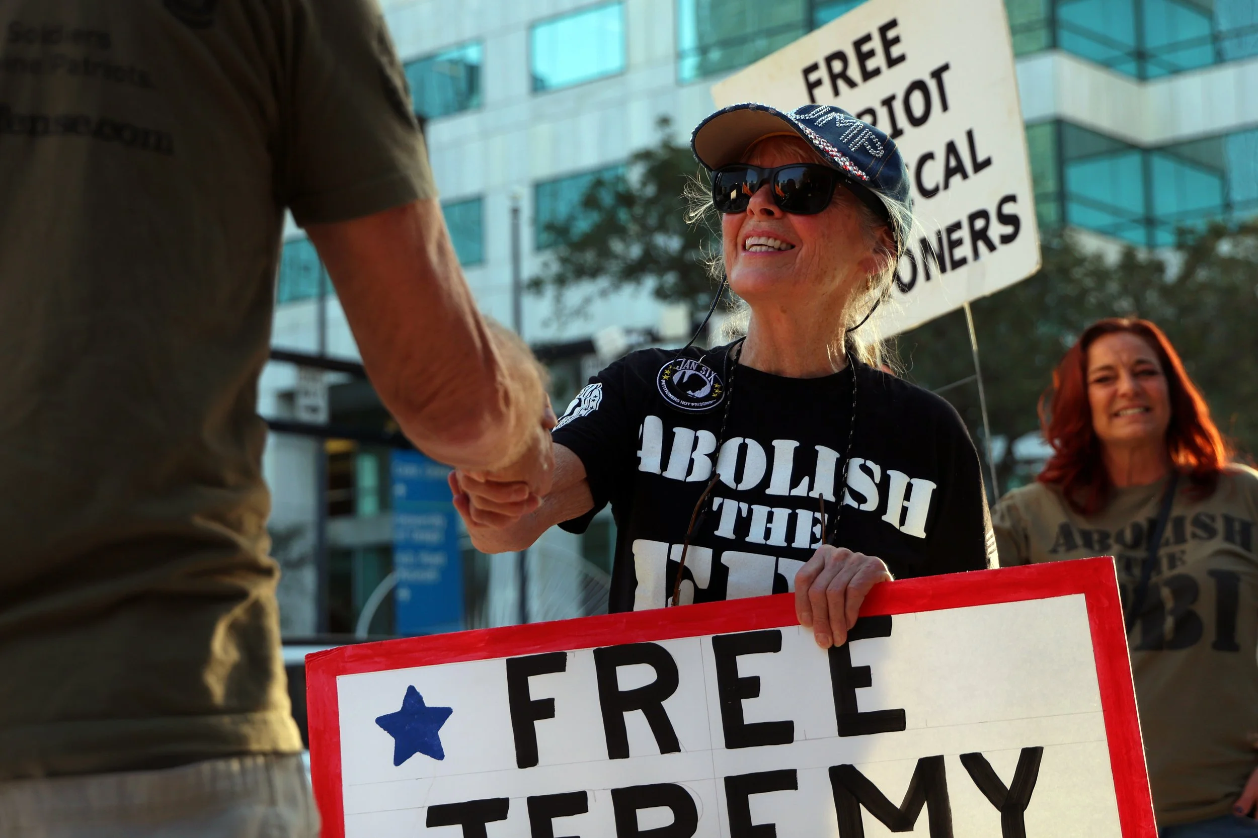 Luanne Bryce shakes a videographers hand during a protest for Jeremey Brown,  a Jan. 6 defendant,  in Tampa, Fla., on Thursday, Jan. 30, 2025.