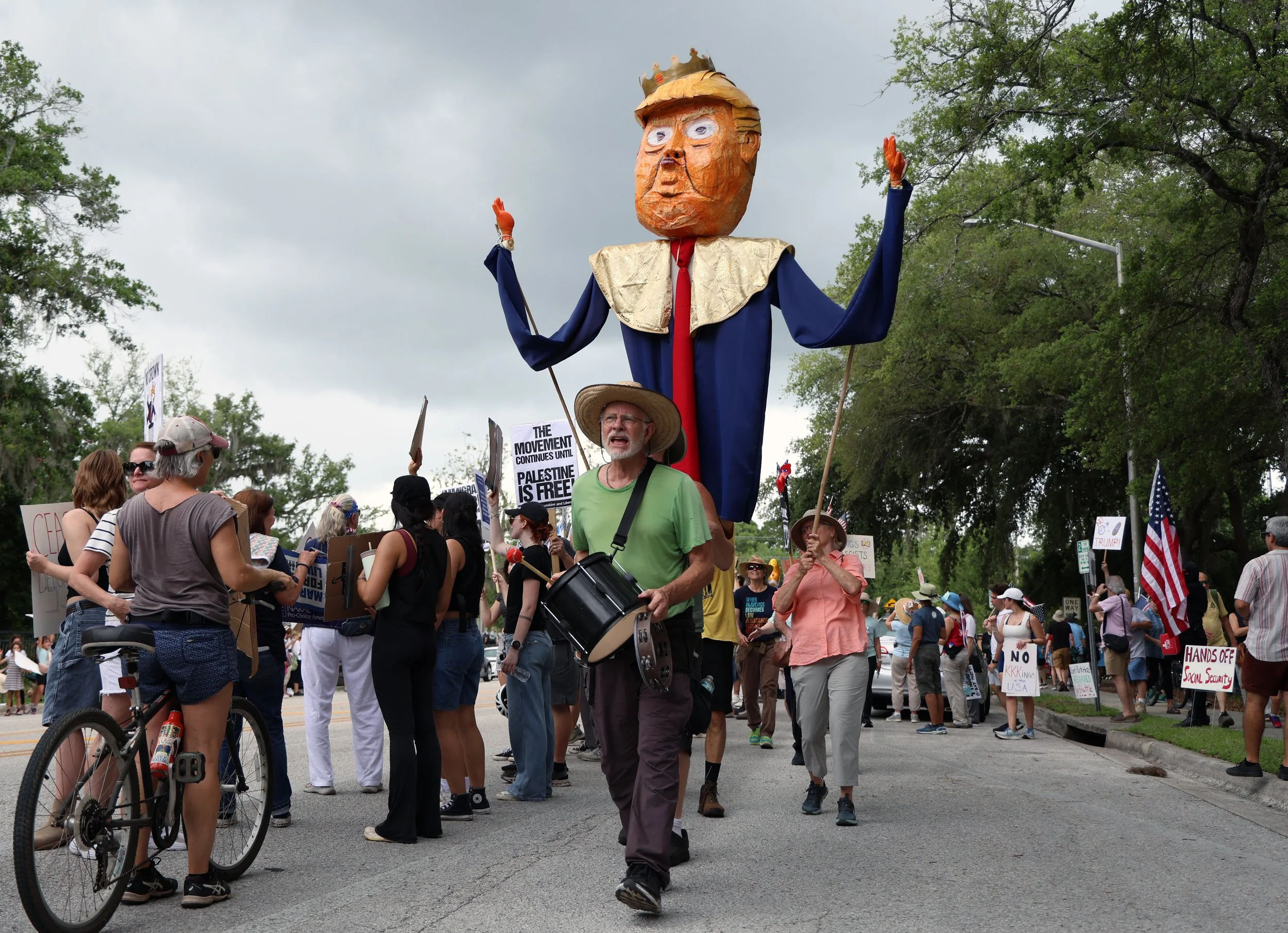 Protestors march with a paper-machete puppet of President Trump down Southwest Sixth Street during the "No Kings Day" protest on Saturday, June 14, 2025.