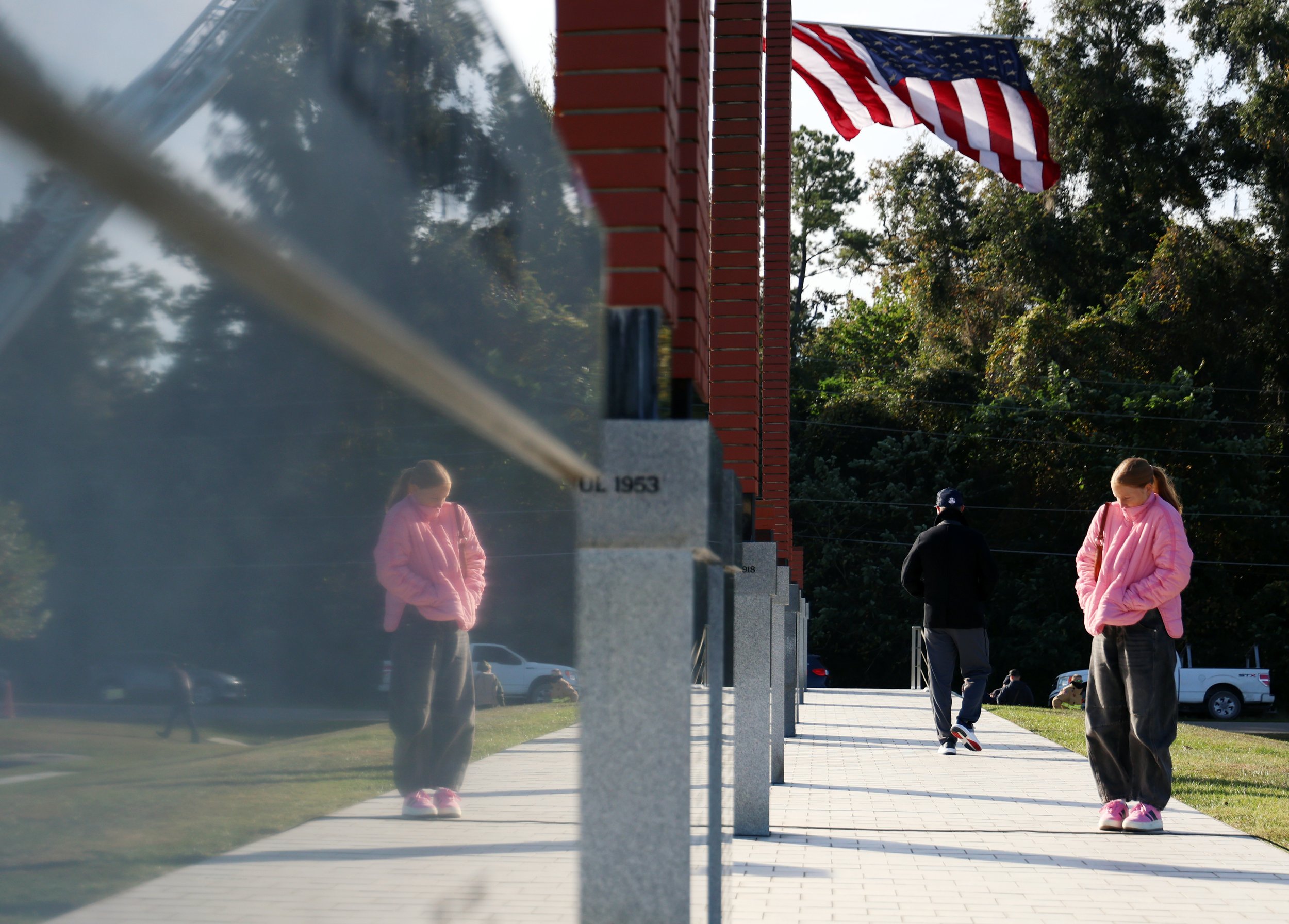 Taylor Dean reads the inscriptions at the base of the “Walk Through Time” veterans memorial, a walkway that traces U.S. military history beginning in 1775, during Alachua County’s Veterans Day celebration at Veterans Memorial Park in Gainesville, Fla