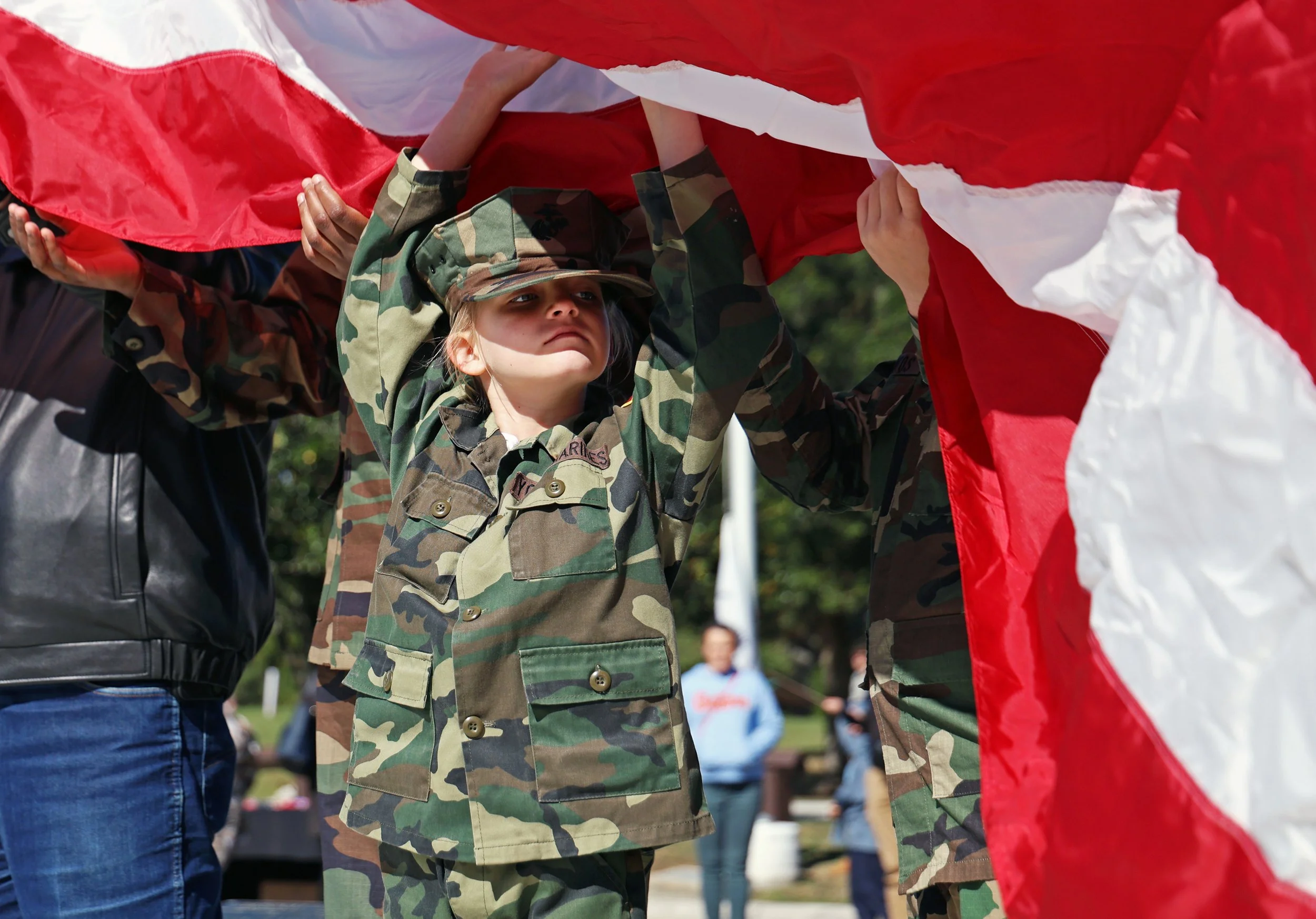 Kaydance Lancaster, a Young Marine Private, lifts up the American flag on the new flagpole during Alachua County’s Veterans Day Celebration at Veterans Memorial Park in Gainesville, Fla., on Tuesday, Nov. 11, 2025.