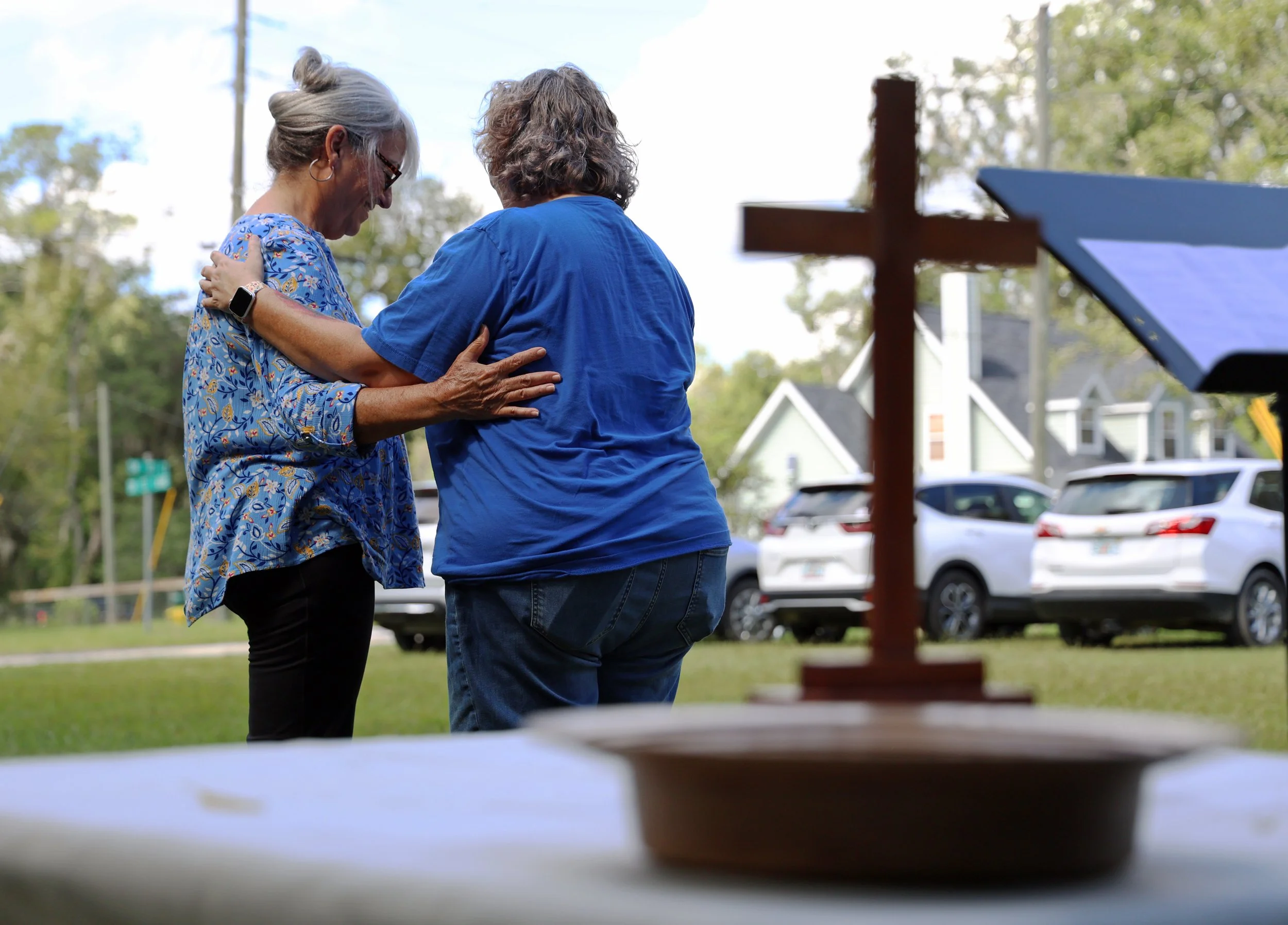 Jean Hunt (left) and Rev. Melissa Pisco (right) hold each other while praying over a photo of Hunt’s dog, Penny, during the Blessing of the Pets service at First Archer United Methodist Church in Archer, Fla., on Sunday, Sept. 28, 2025. (Libby Clifto