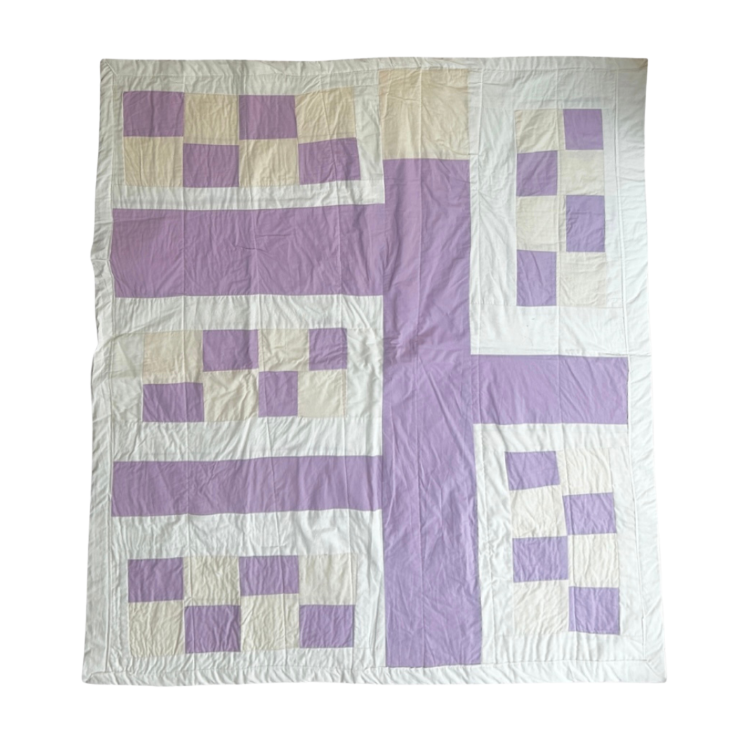 A quilt with a geometric pattern featuring purple and white squares and rectangles arranged in a symmetrical design.