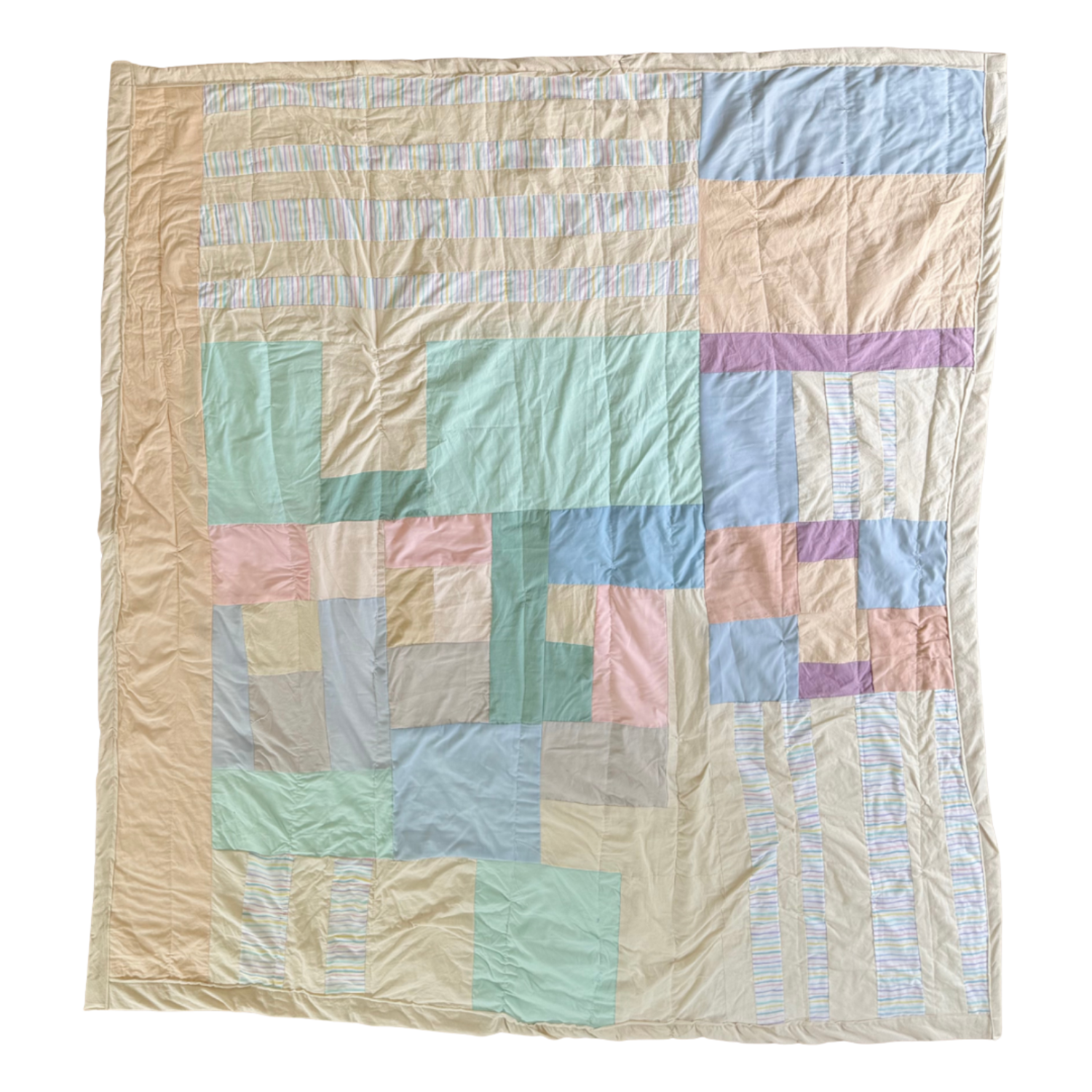 Colorful quilt with pastel patches and striped sections, laid out flat on a surface.