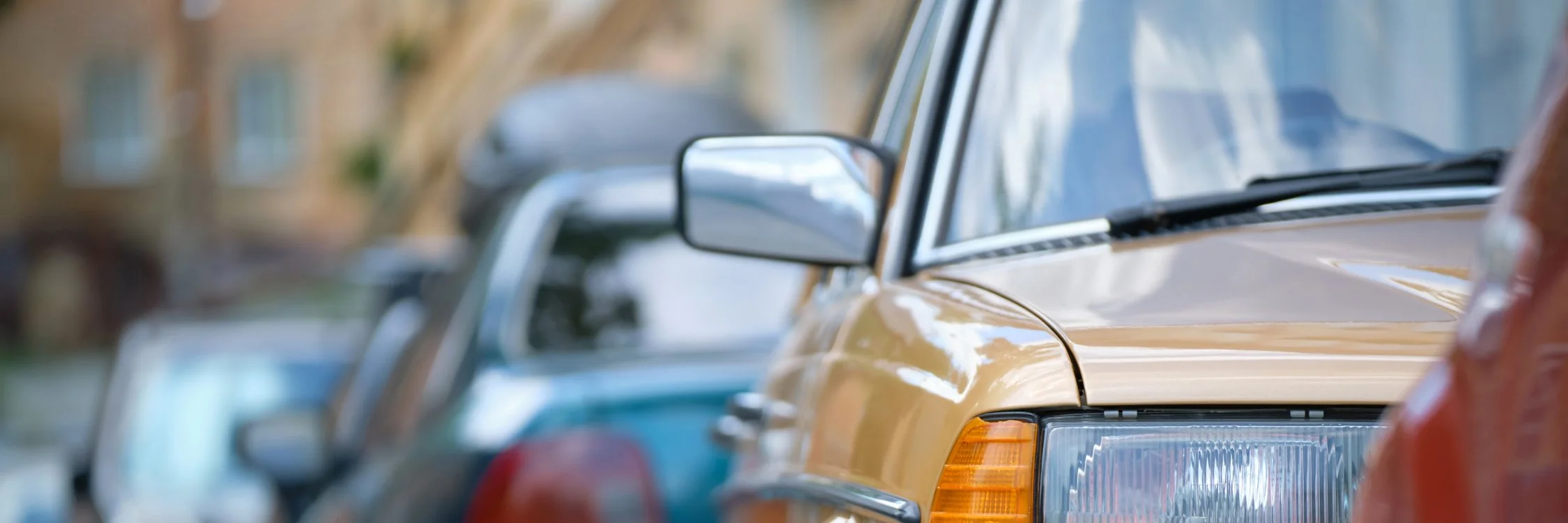 Two women smiling while shopping for clothes at a store, surrounded by hanging garments and wearing sunglasses.