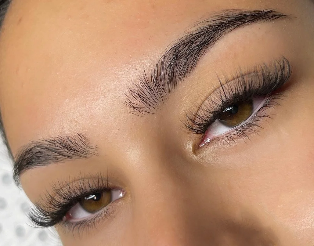 Close-up of a woman's eye with well-groomed eyebrows and long eyelashes.