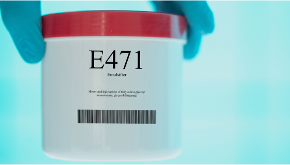 A person wearing blue gloves holding a white container labeled with E471 Emulsifier, illustrating common bioengineered food additives used to alter texture and extend shelf life.