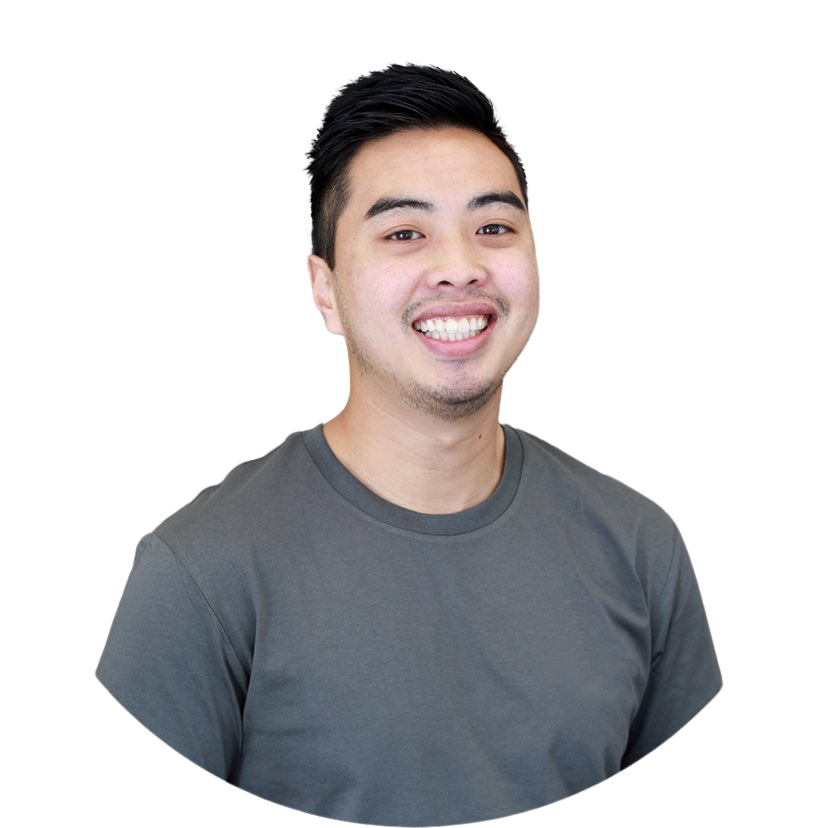 A young man with dark hair smiling and wearing a gray t-shirt.