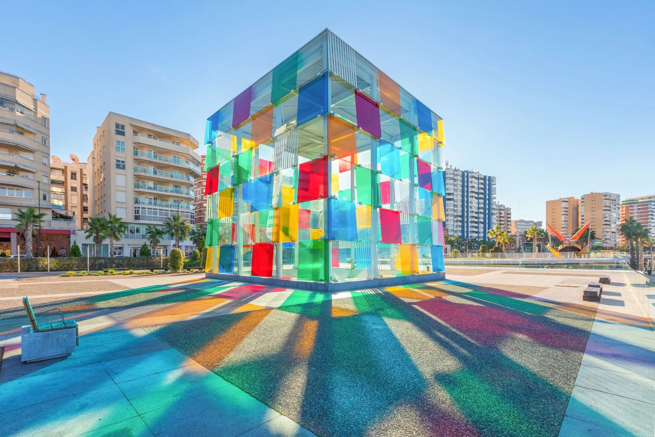 Exterior view of the Centre Pompidou Málaga featuring a cube-like building of colored glass panels.