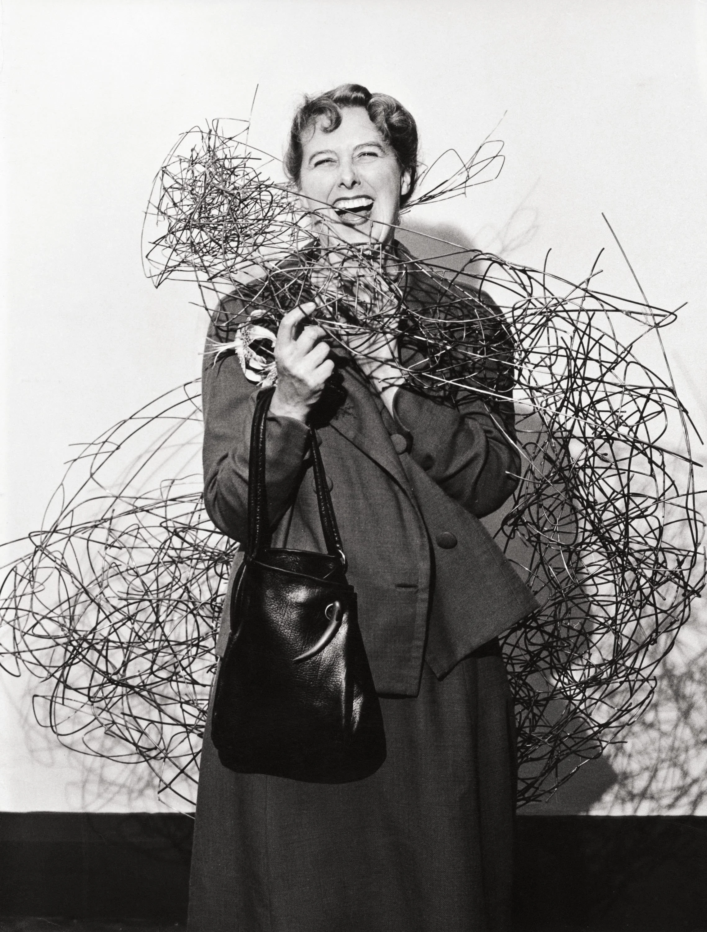 Claire Falkenstein surrounded by  Sun #11  at Galerie Stadler, Paris, France, 1957. Claire Falkenstein Papers, Archives of American Art, Smithsonian Institution 