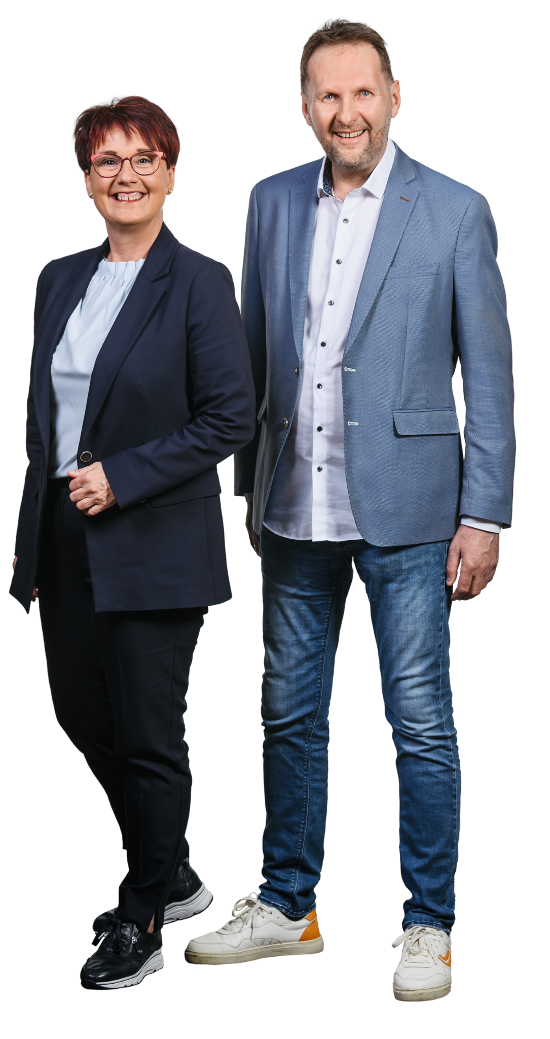 Zwei professionell gekleidete Menschen, eine Frau und ein Mann, stehen nebeneinander, lächelnd, vor einem schwarzen Hintergrund.