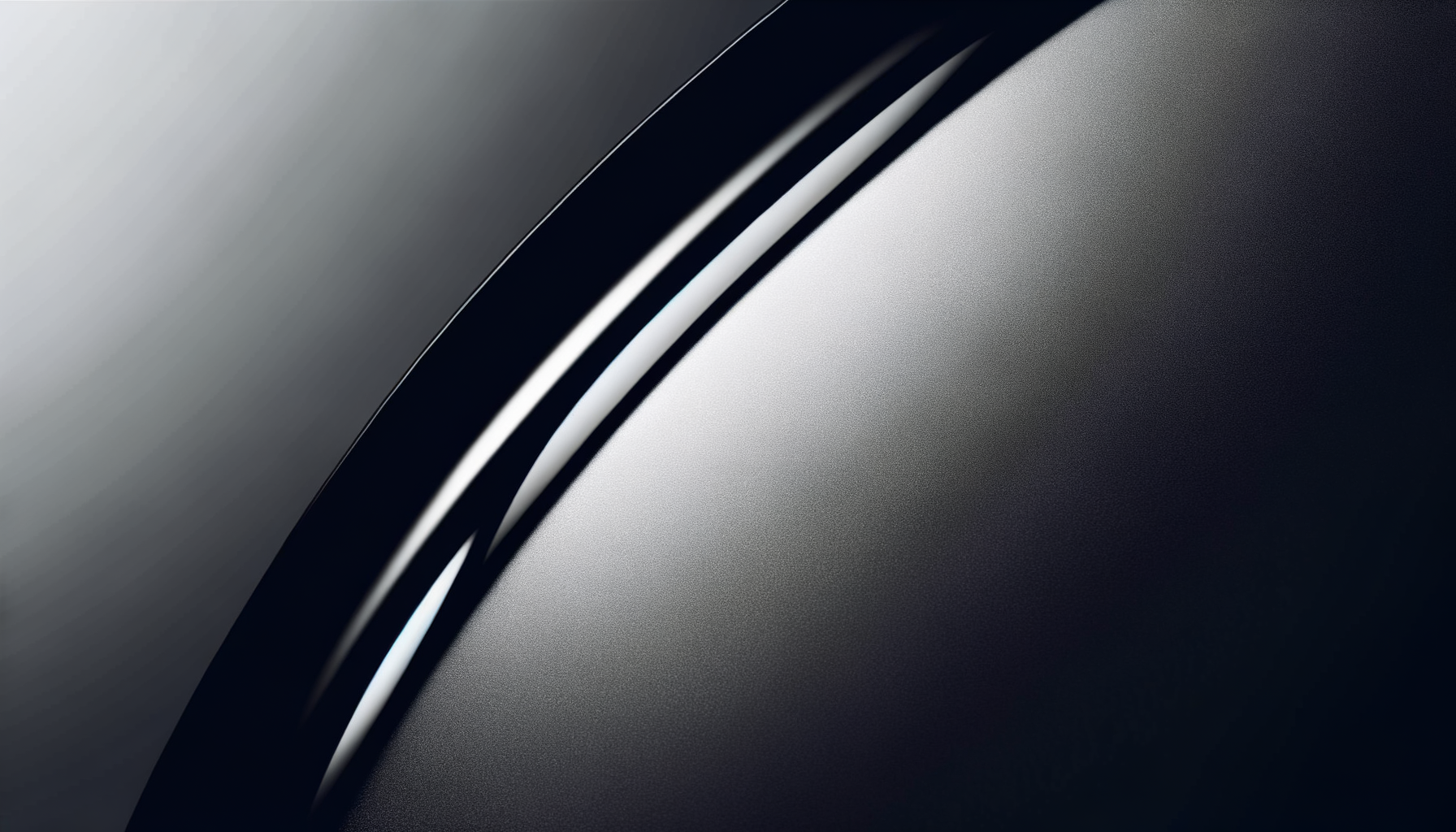 Close-up of a sleek, metallic, black surface with a curved silver edge.