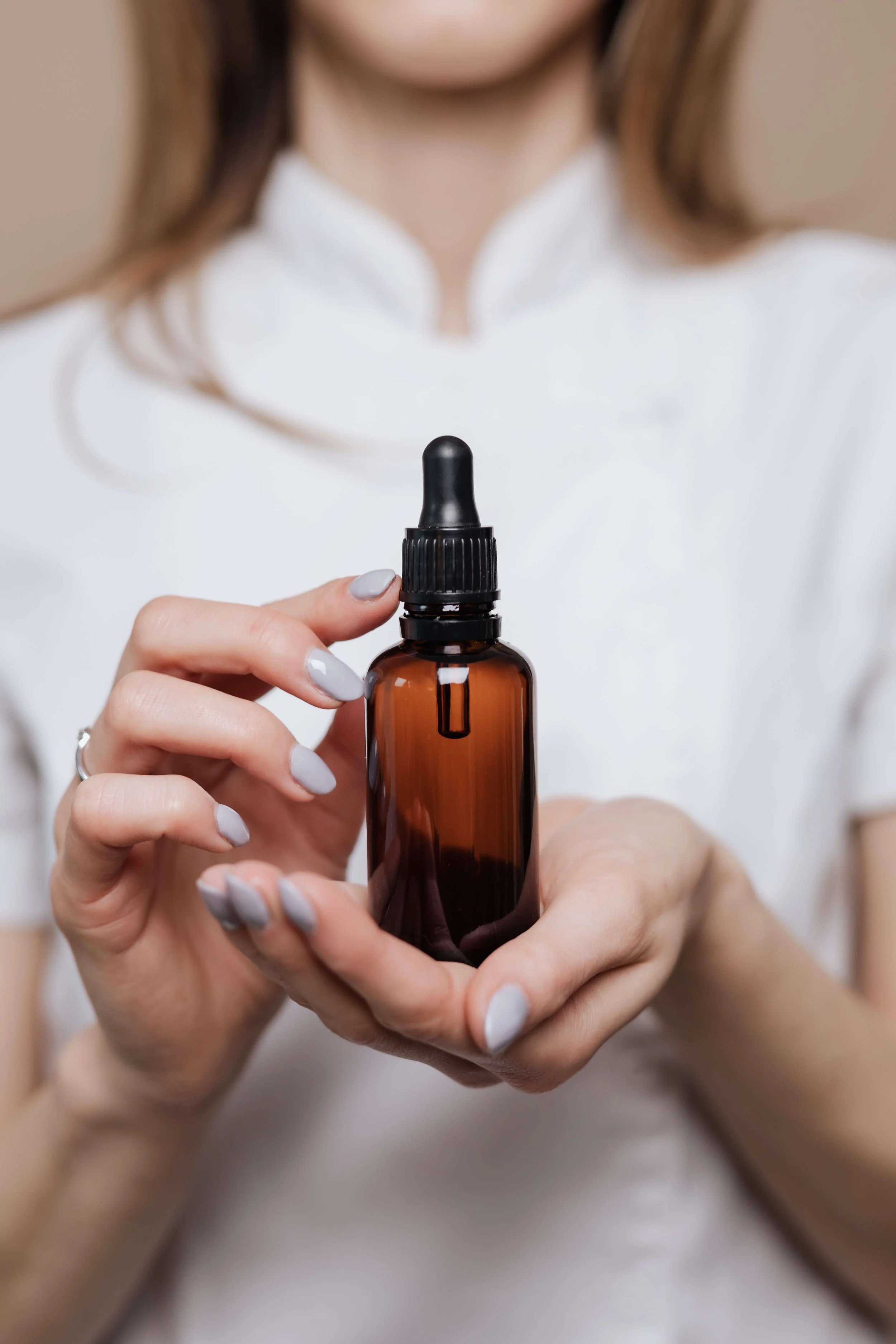 hands holding herbal tincture Marina Danilova Clinic