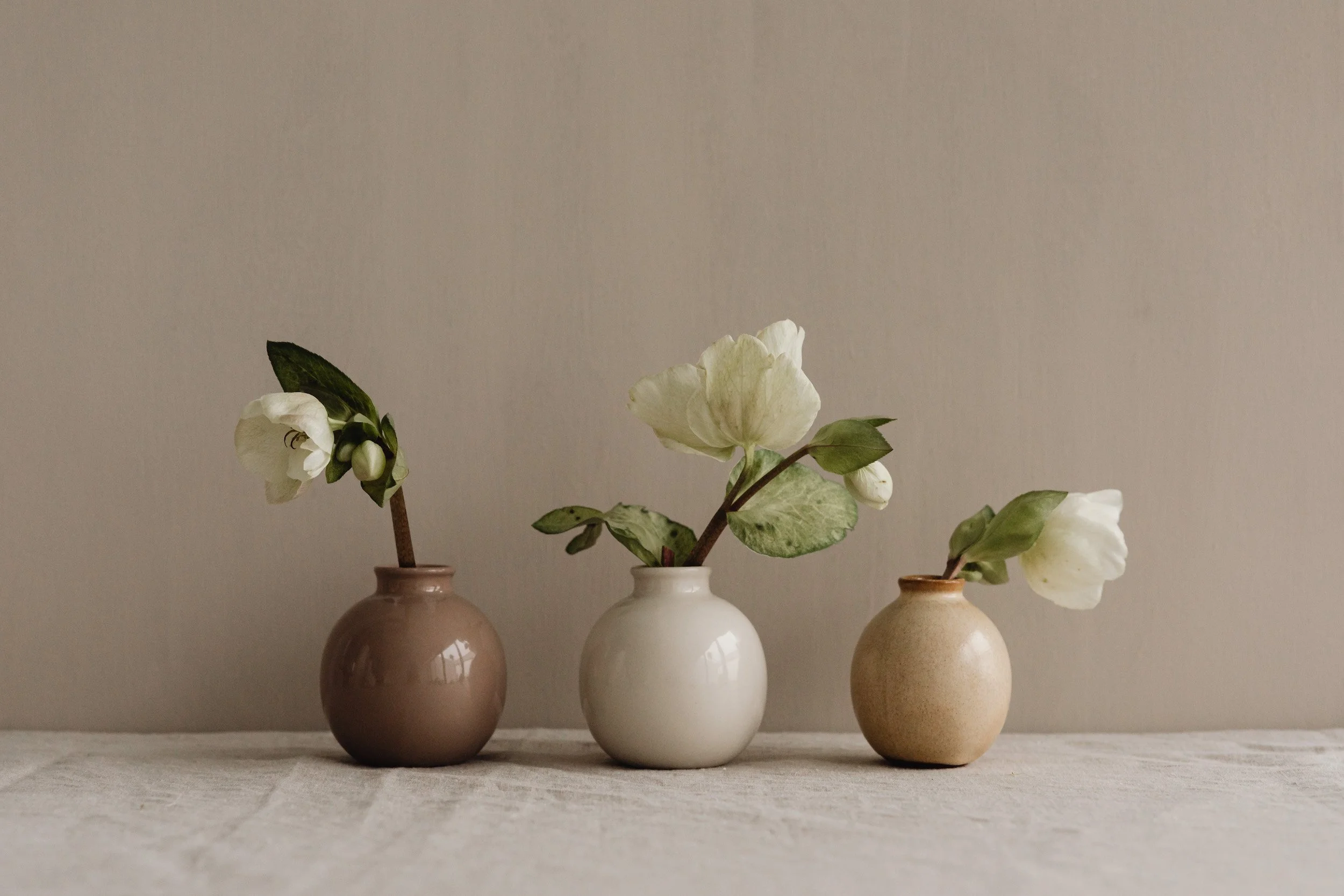 three ceramic vases with white flowers