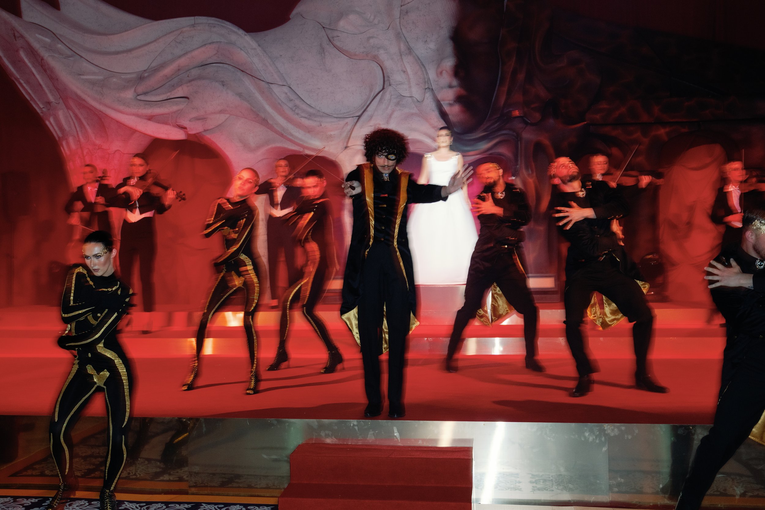 dancers in a black and gold inspired costume with soprano and orchestra