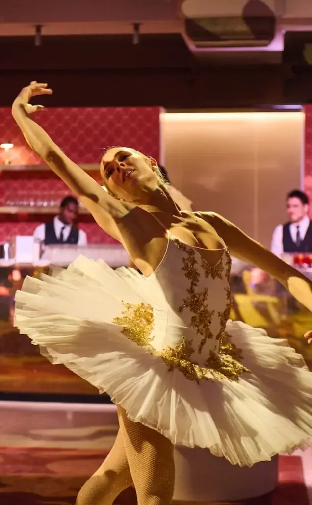Ballerina in gold-embellished white tutu performing at upscale wedding reception