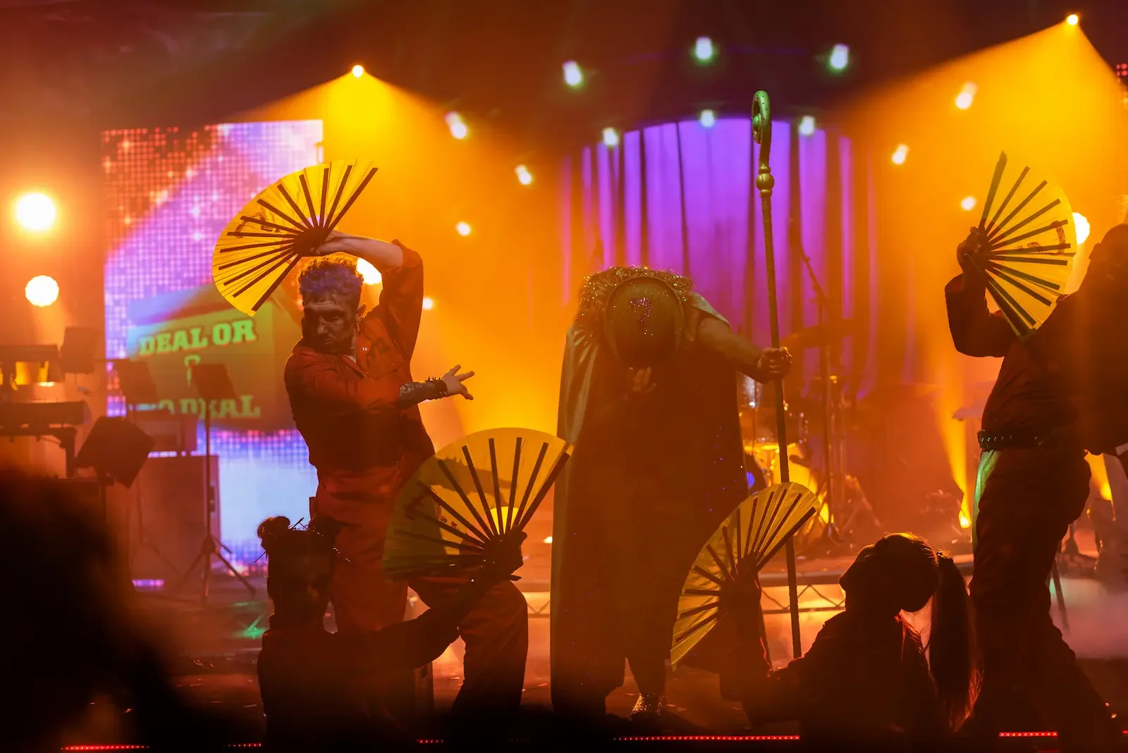 Performers dancing under colorful stage lights for a private Halloween party.