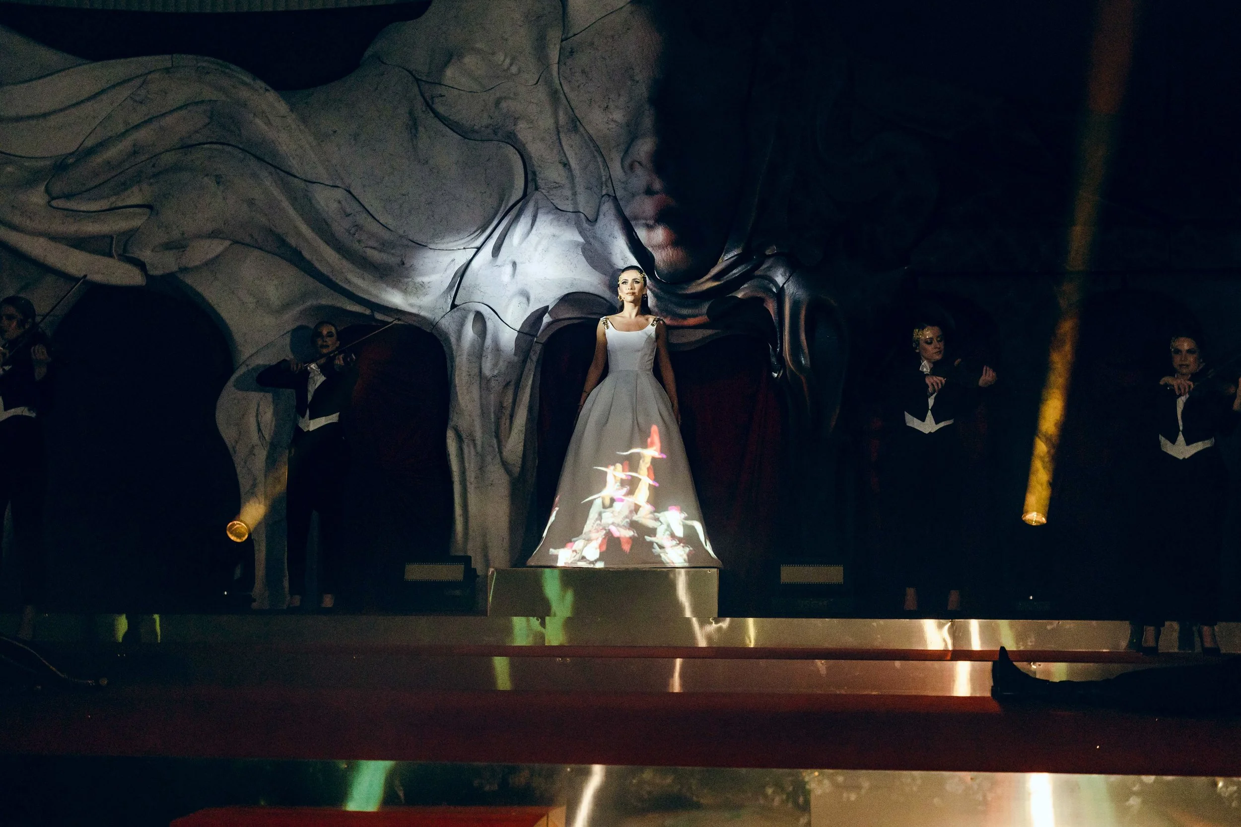 soprano performing with a projection mapped dress and orchestra