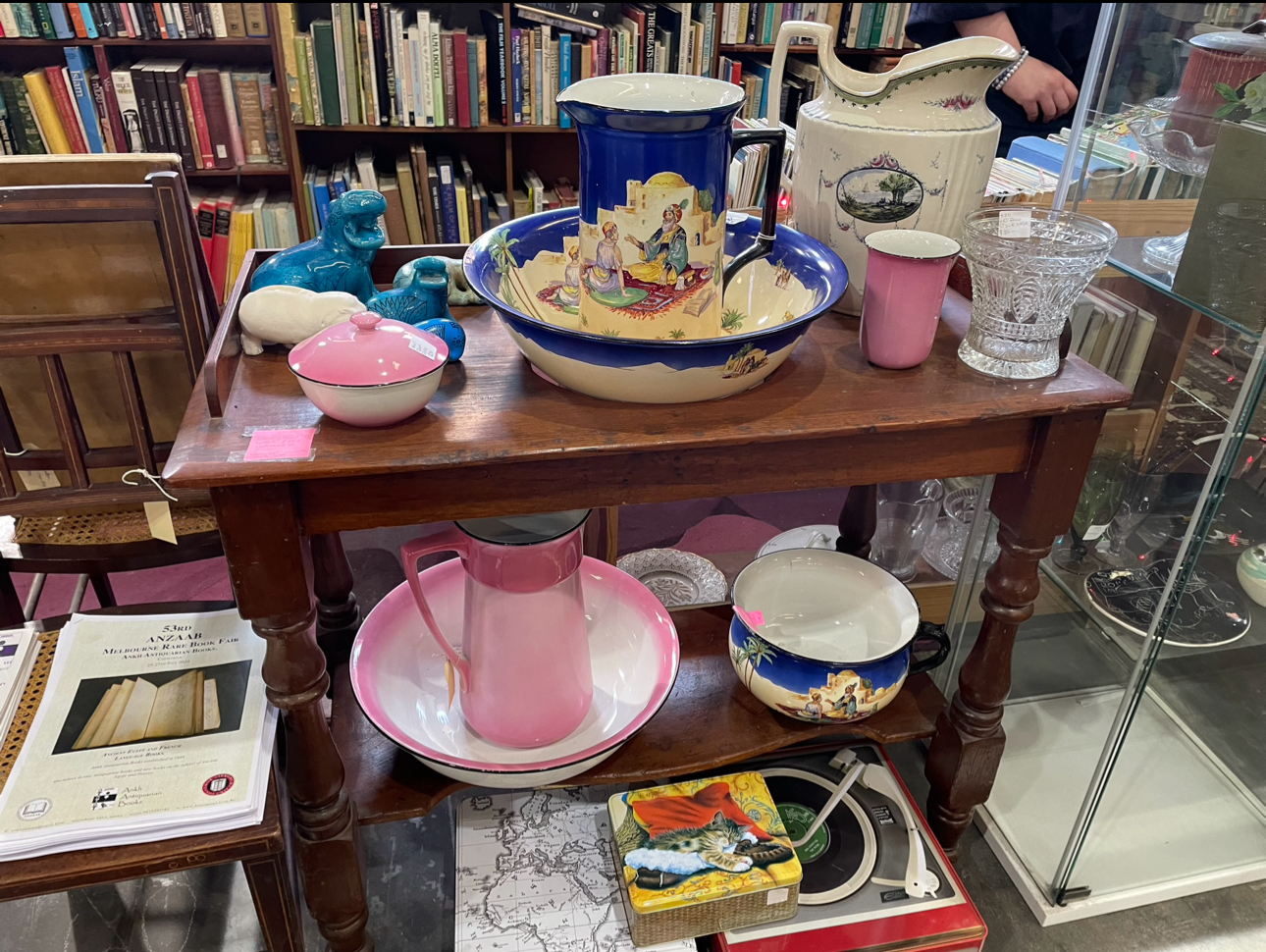 A wooden display table with various decorative and vintage items, at Waverley Antique Bazaar Stall H20.