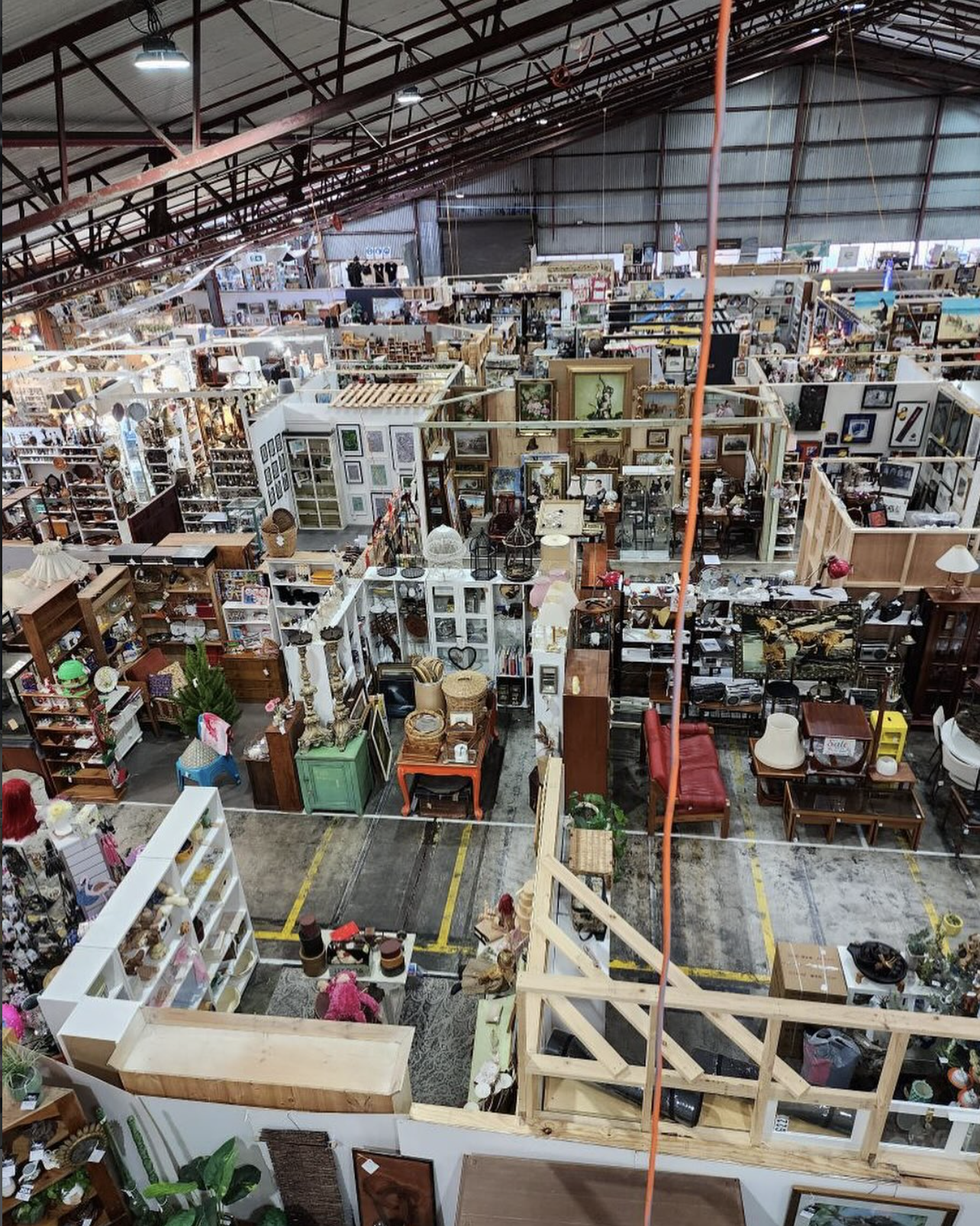 Indoor Waverly Antique Bazaar, with multiple aisles filled with vintage furniture, lamps, artwork, and home decor items.