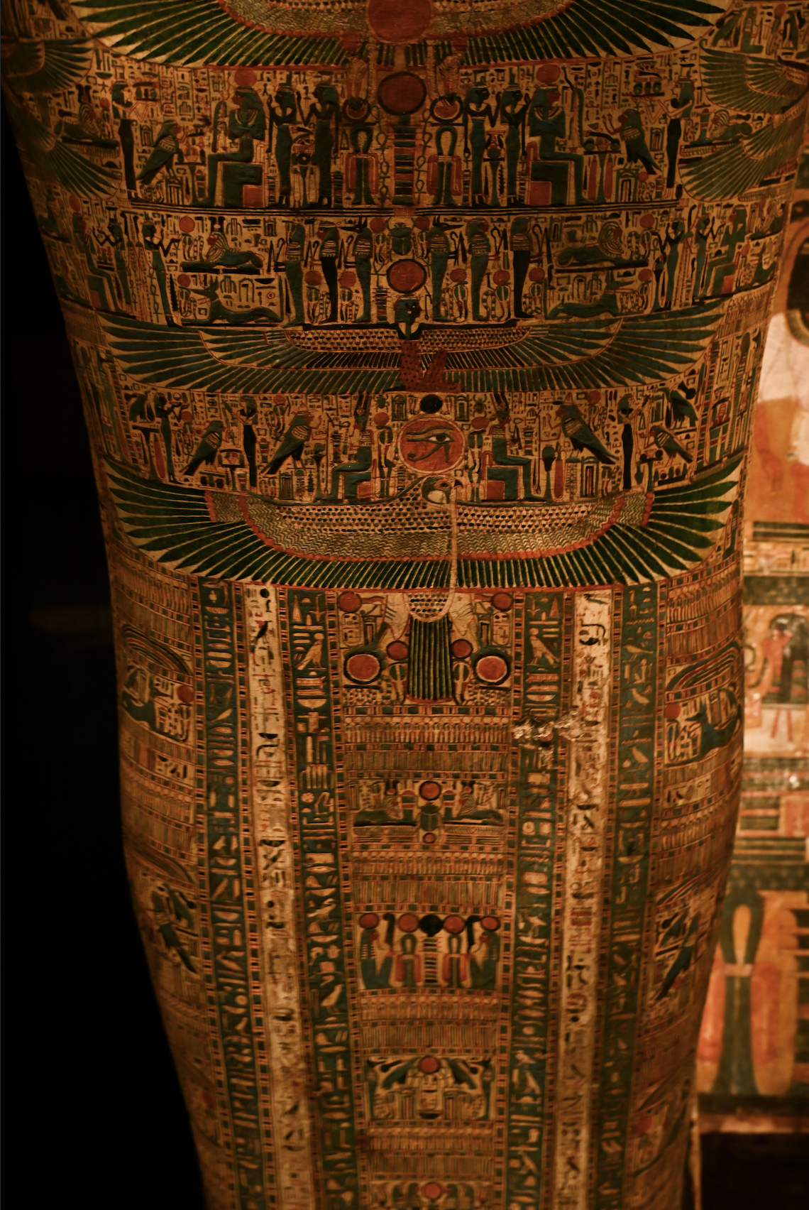 Close-up of ancient Egyptian painted hieroglyphs and symbols on an ornate artifact.