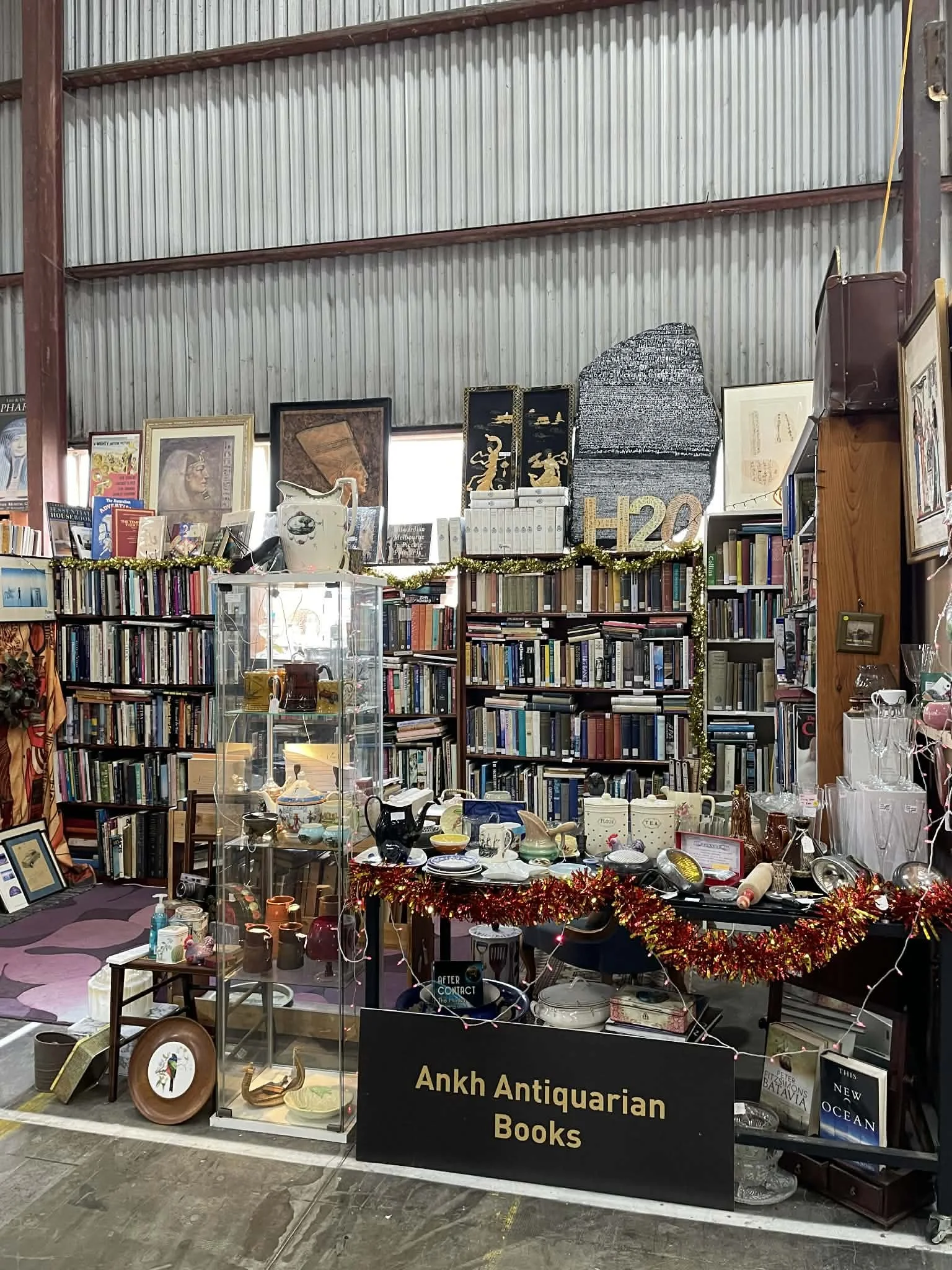 Bookstore display with bookshelves, vintage items, at Waverley Antique Bazaar Stall H20.