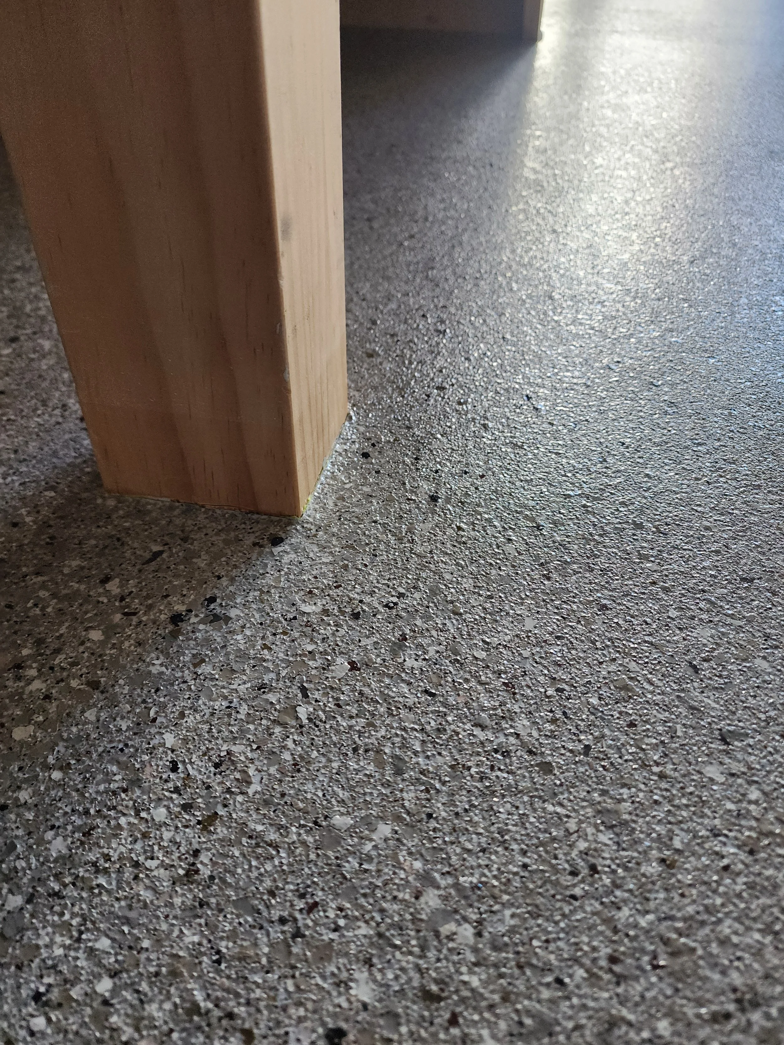A clean, empty garage with gray cabinets and a polished concrete floor.